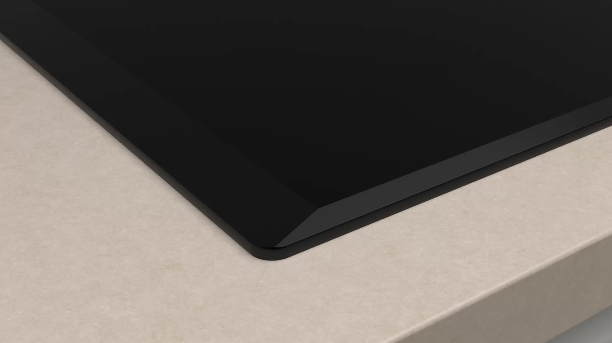 Zbliżenie czarnej płyty grzewczej na beżowym blacie.