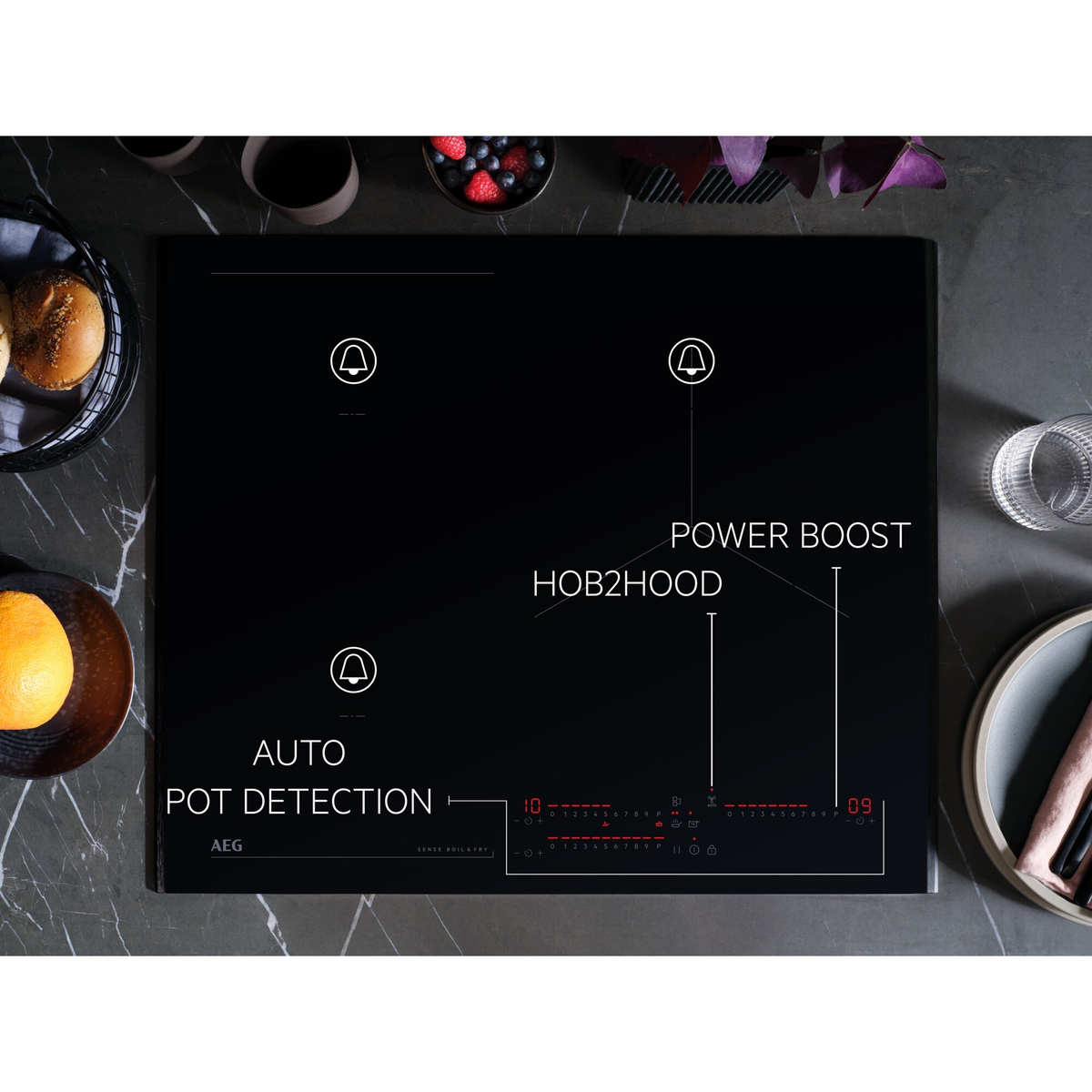 Placa de inducción negra con controles táctiles, alimentos y etiquetas de texto.