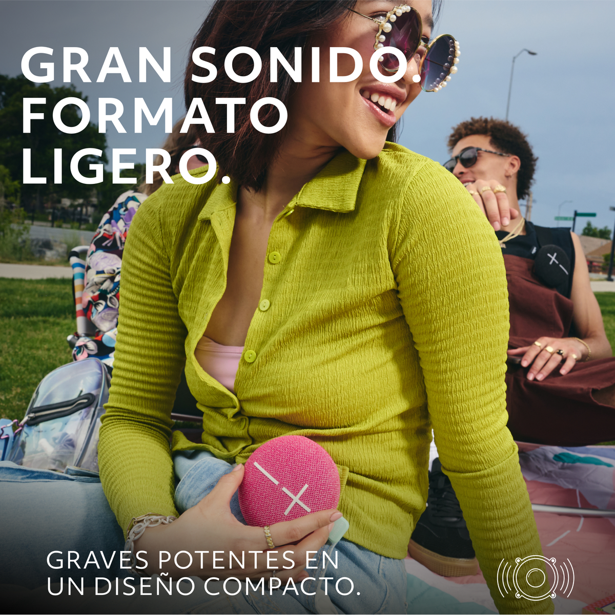 Dwie uśmiechnięte osoby trzymające różowy, okrągły głośnik. Tekst brzmi: 'GRAN SONIDO. FORMATO LIGERO'.