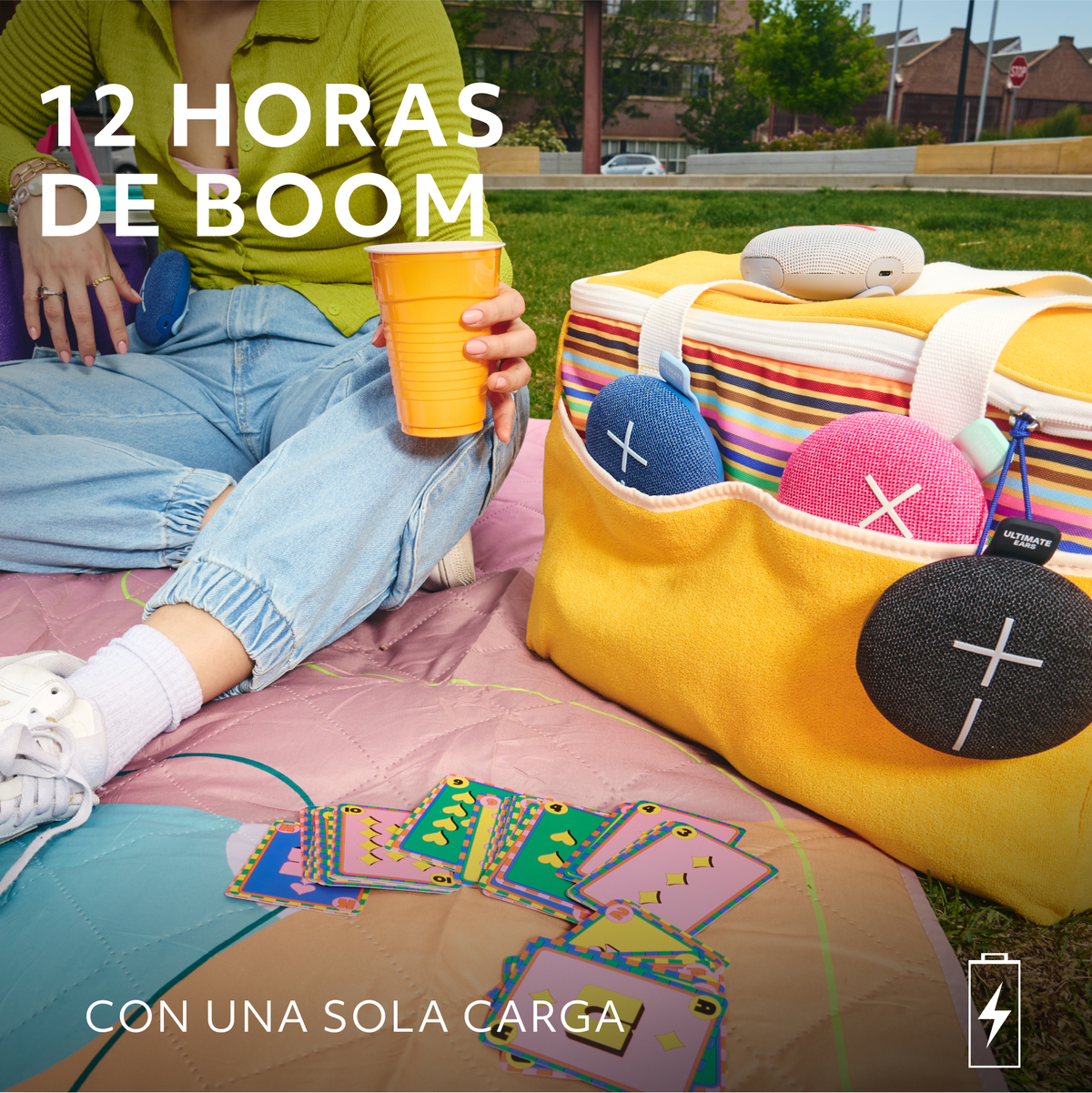 Ludzie na pikniku z głośnikami, napojami i kartami.