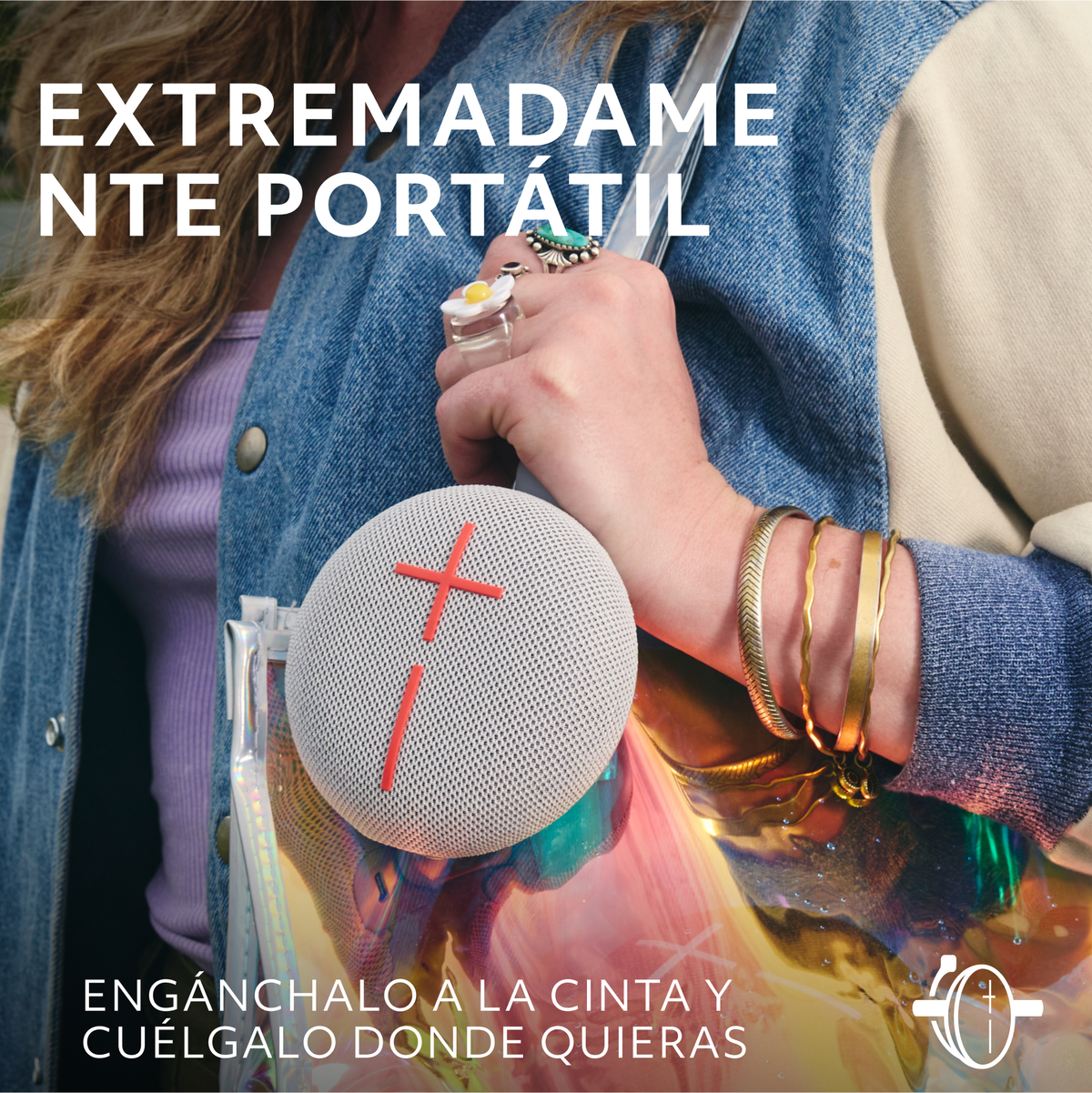Kobieta trzyma biało-czerwony głośnik. Tekst w języku hiszpańskim: "EXTREMADAMENTE PORTÁTIL" i "ENGANCHALO A LA CINTA".