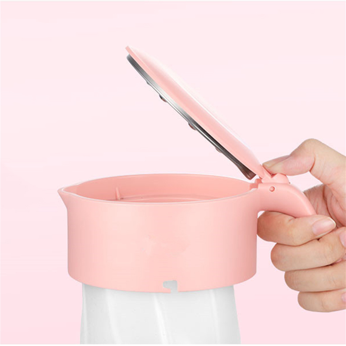Ein rosa Babykostzubereiter mit offenem Deckel, gehalten von einer Hand. Der Hintergrund ist rosa.