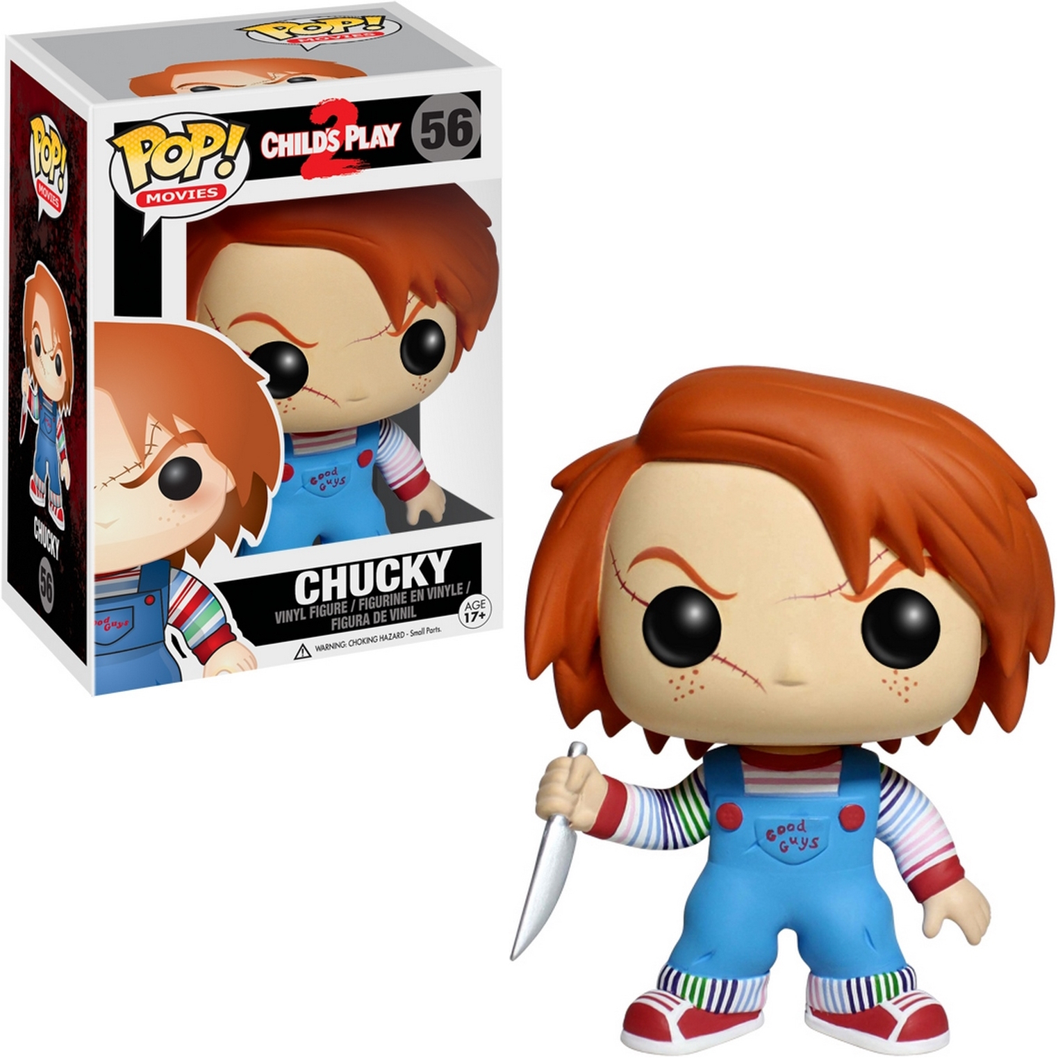 Lalka Chucky z nożem przed pudełkiem. Ma rude włosy i niebieskie ogrodniczki.