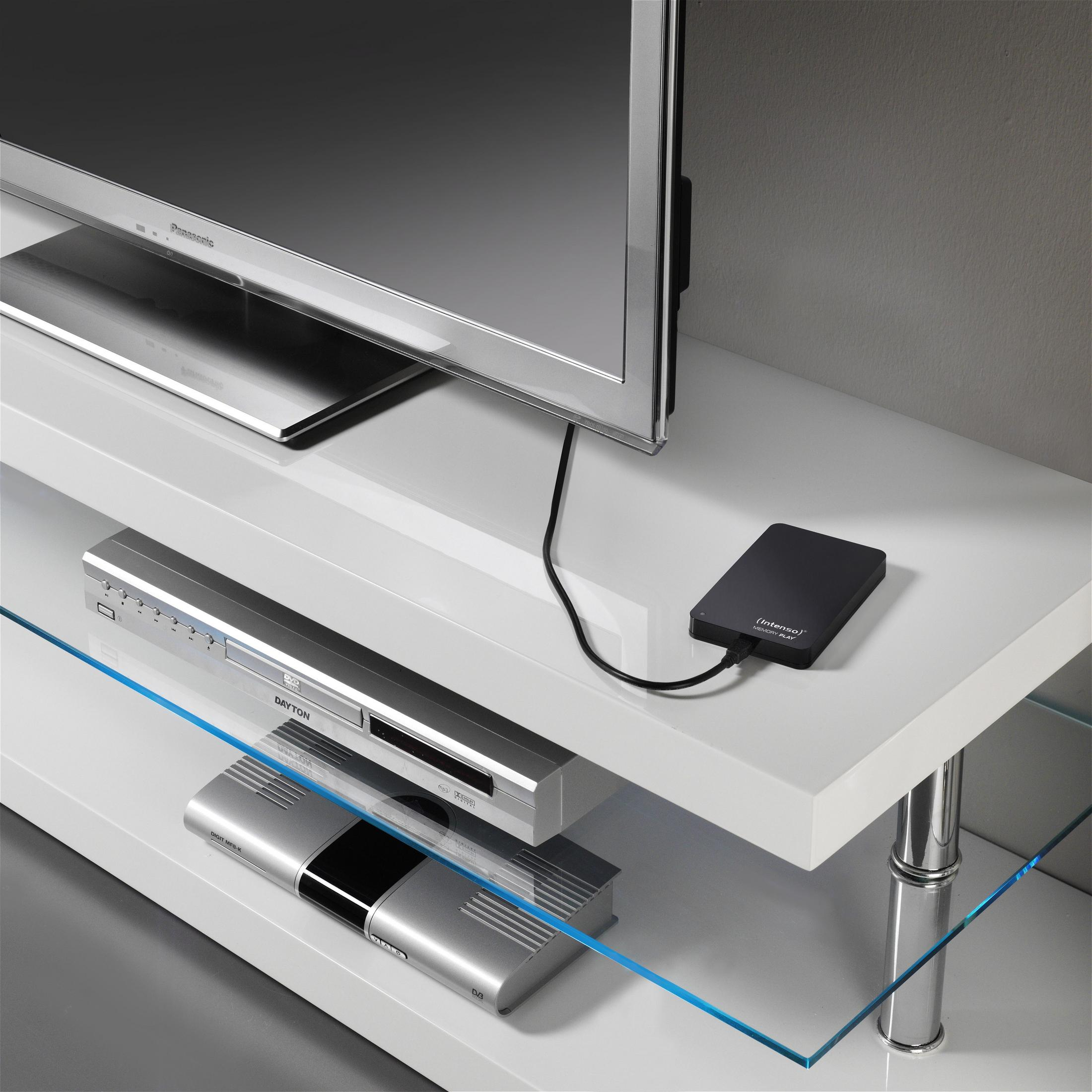 Biała szafka RTV z telewizorem na górze i elektroniką poniżej, w tym odtwarzacz multimedialny i dysk twardy.