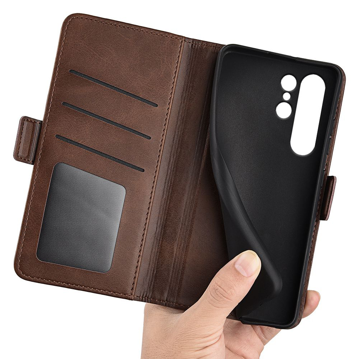 Une main tient un étui de téléphone marron ouvert. L'intérieur de l'étui est noir, le devant est marron.