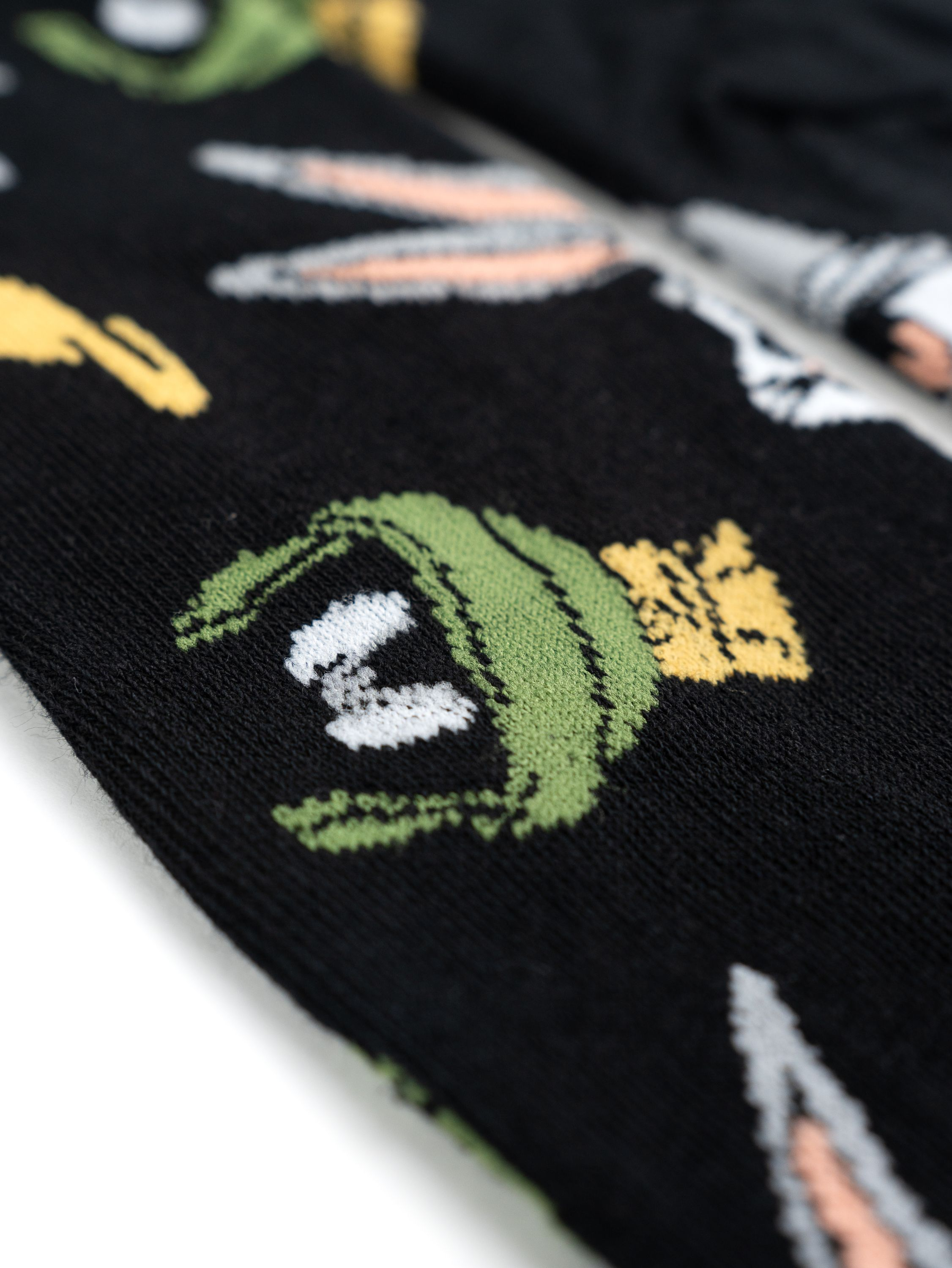 Nahaufnahme eines schwarzen Stoffes mit aufgedruckten Looney Tunes-Charakteren. Bugs Bunny, Taz und andere.