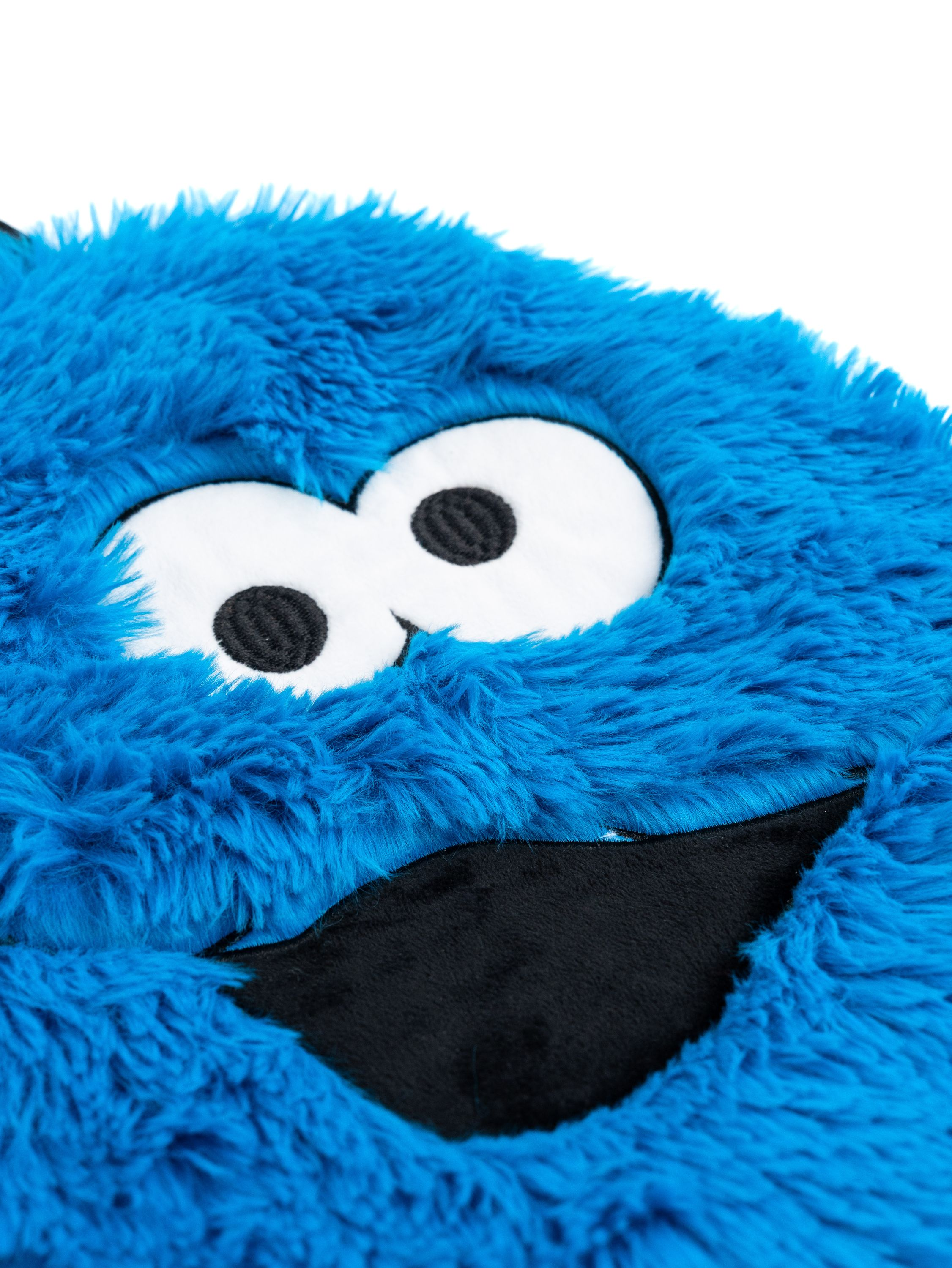 Nahaufnahme eines Cookie Monster Plüschkopfes, blaues Fell, weiße Augen und schwarzer Mund.