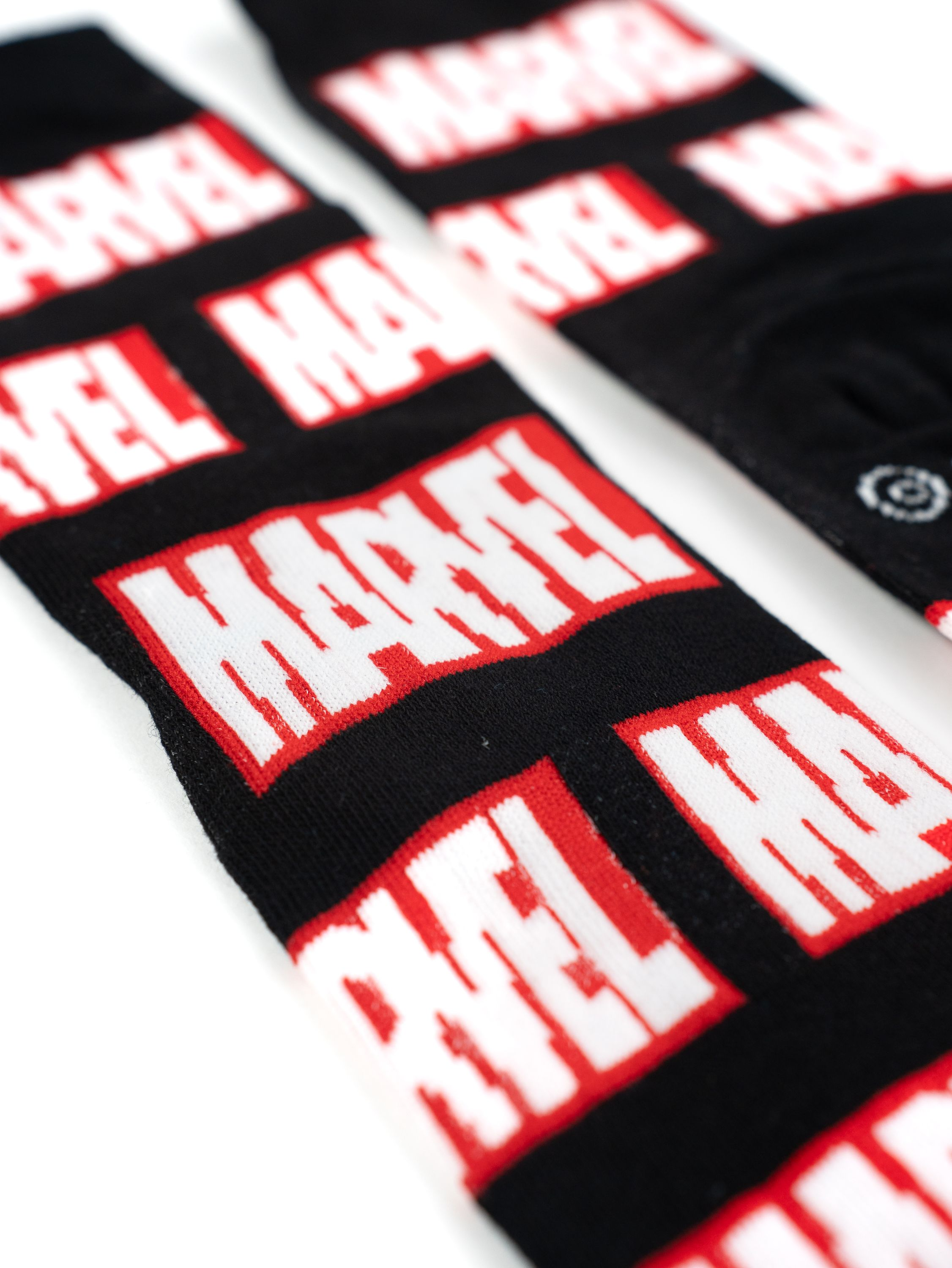 Schwarze Socken mit sich wiederholendem weißen Marvel-Logo.