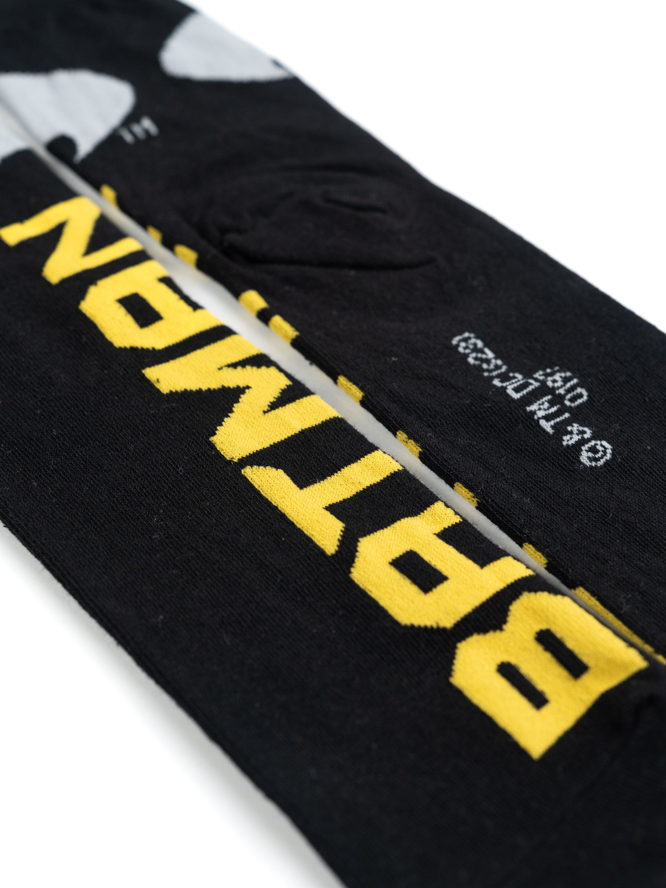 Schwarze Batman-Socken mit gelbem Text. Das Batman-Logo befindet sich oben.