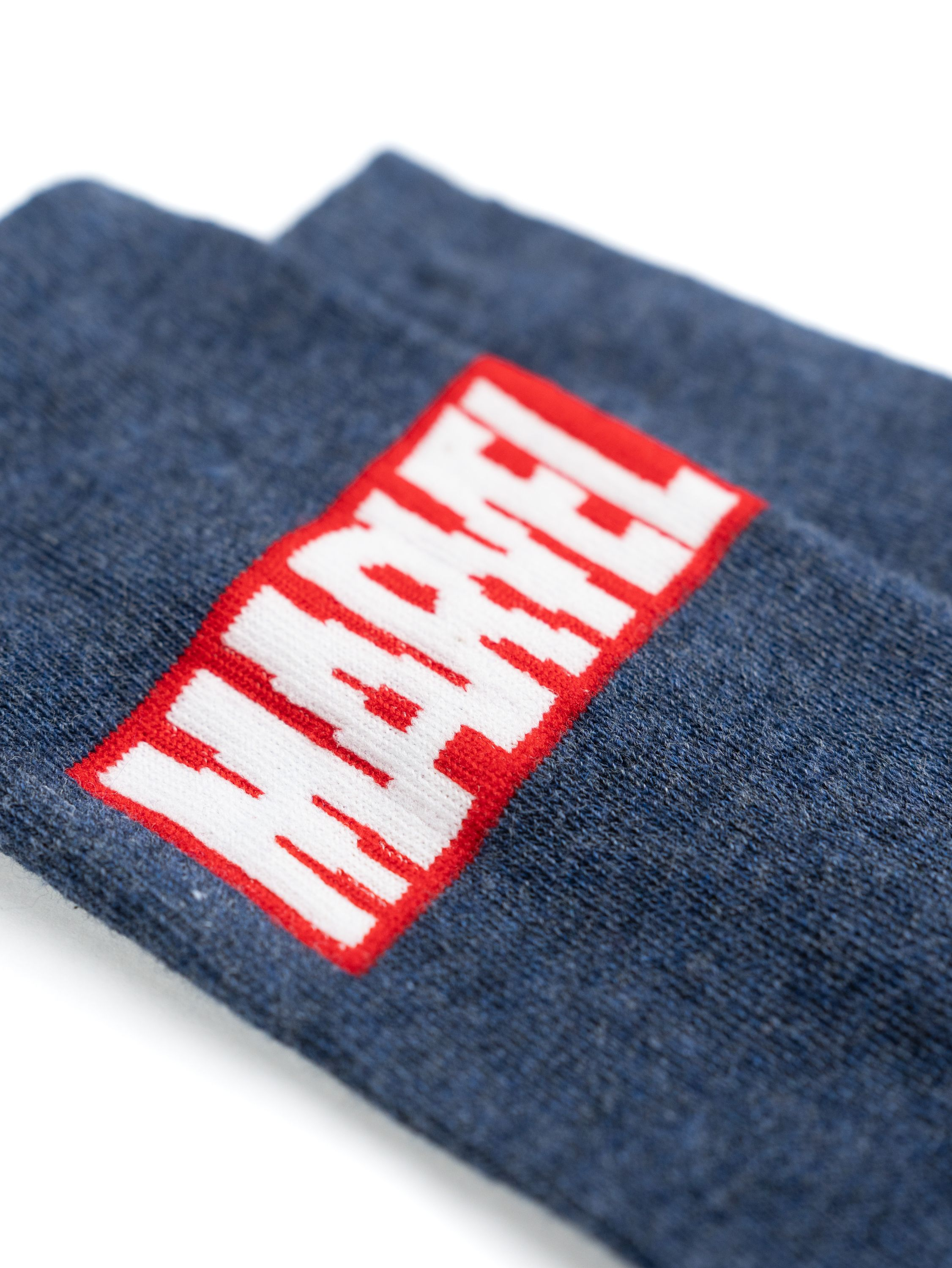 Nahaufnahme von Marvel-Socken mit rotem Marvel-Logo auf blauem Stoff.