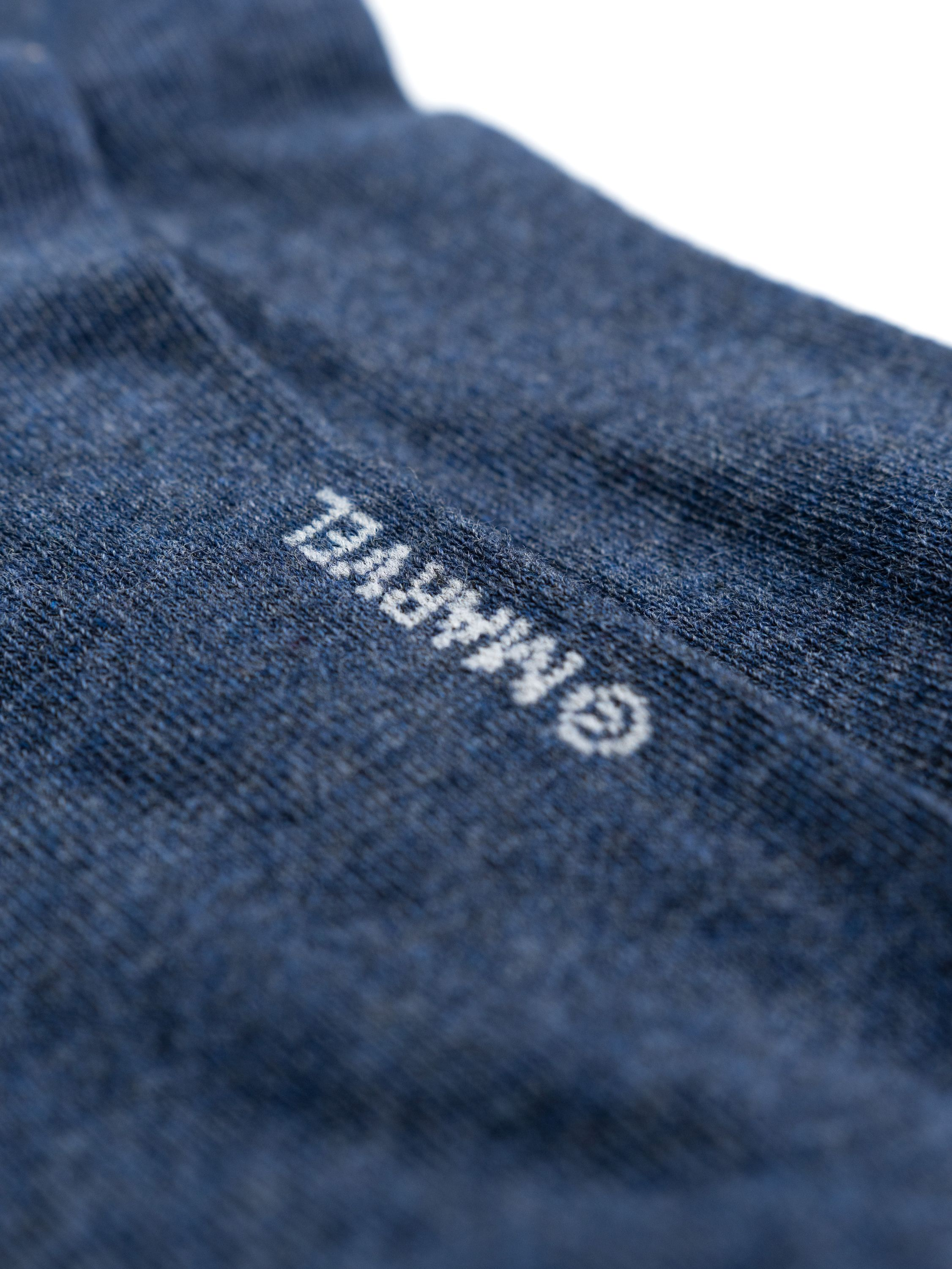Blaue Socken mit weißem Marvel-Logo. Nahaufnahme.