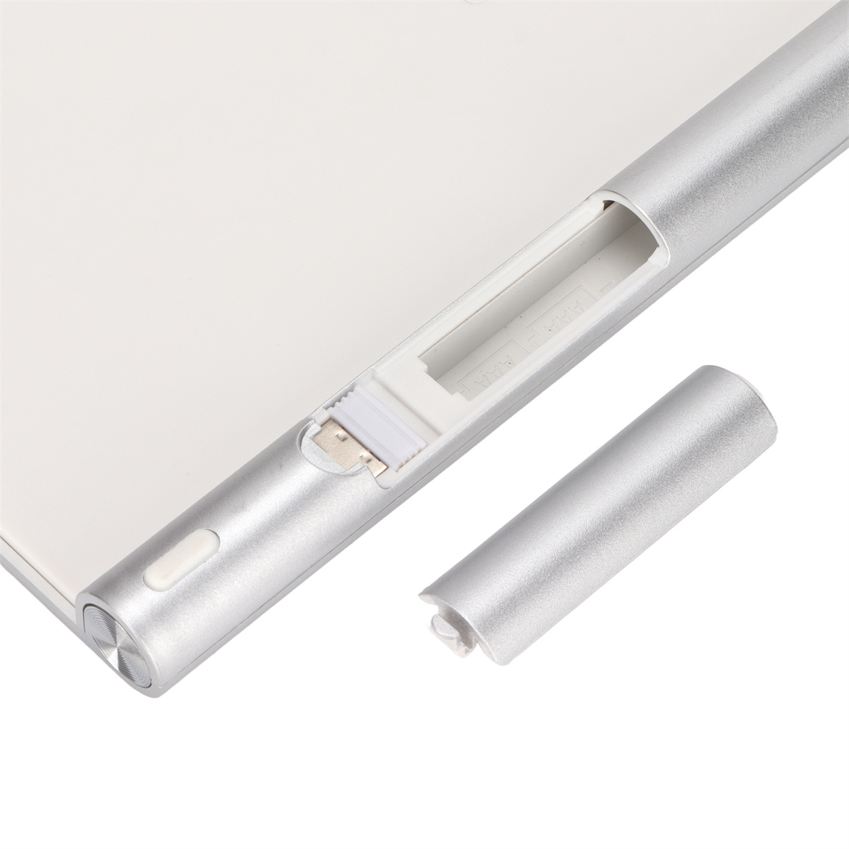 Silberner Stift mit abgenommener Kappe, die den Ladeanschluss zeigt, auf weißem Untergrund.