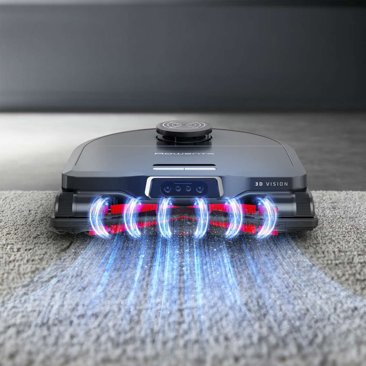 Una aspiradora robot negra y gris. Está sobre una alfombra y emite luces.