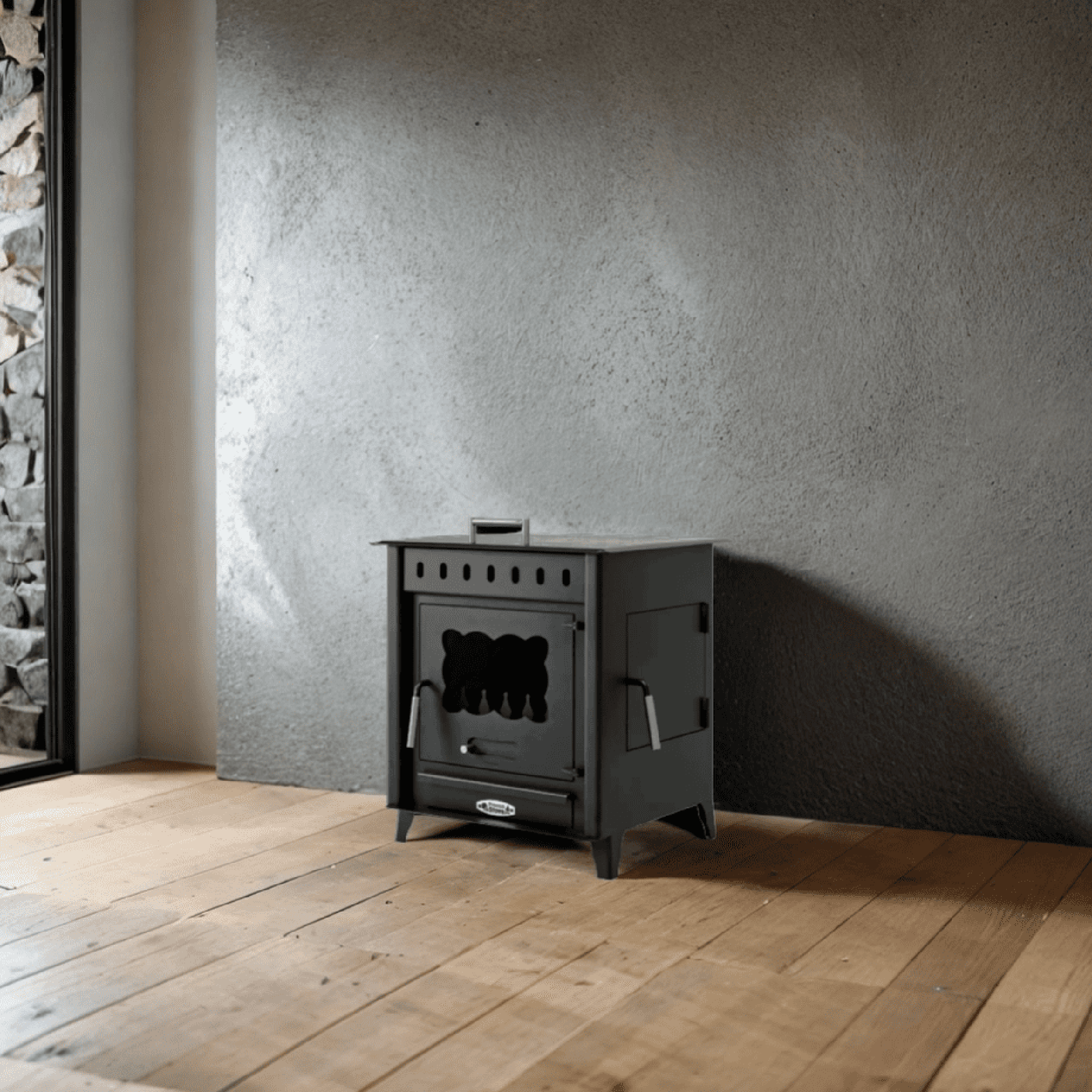 Una estufa negra contra una pared gris y un suelo de madera, creando un ambiente acogedor.
