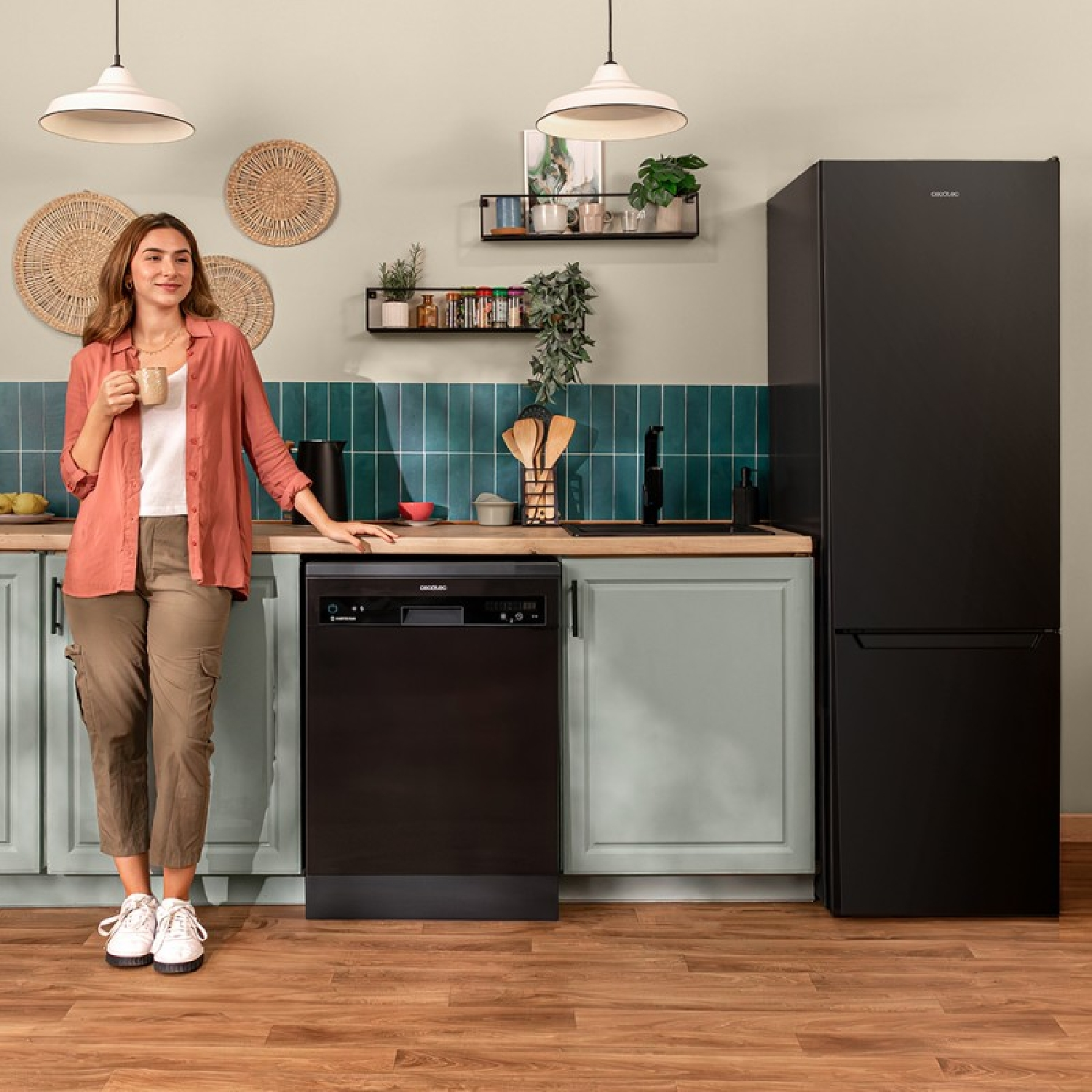 Mujer en cocina con lavavajillas, nevera y taza. Gabinetes verde claro.