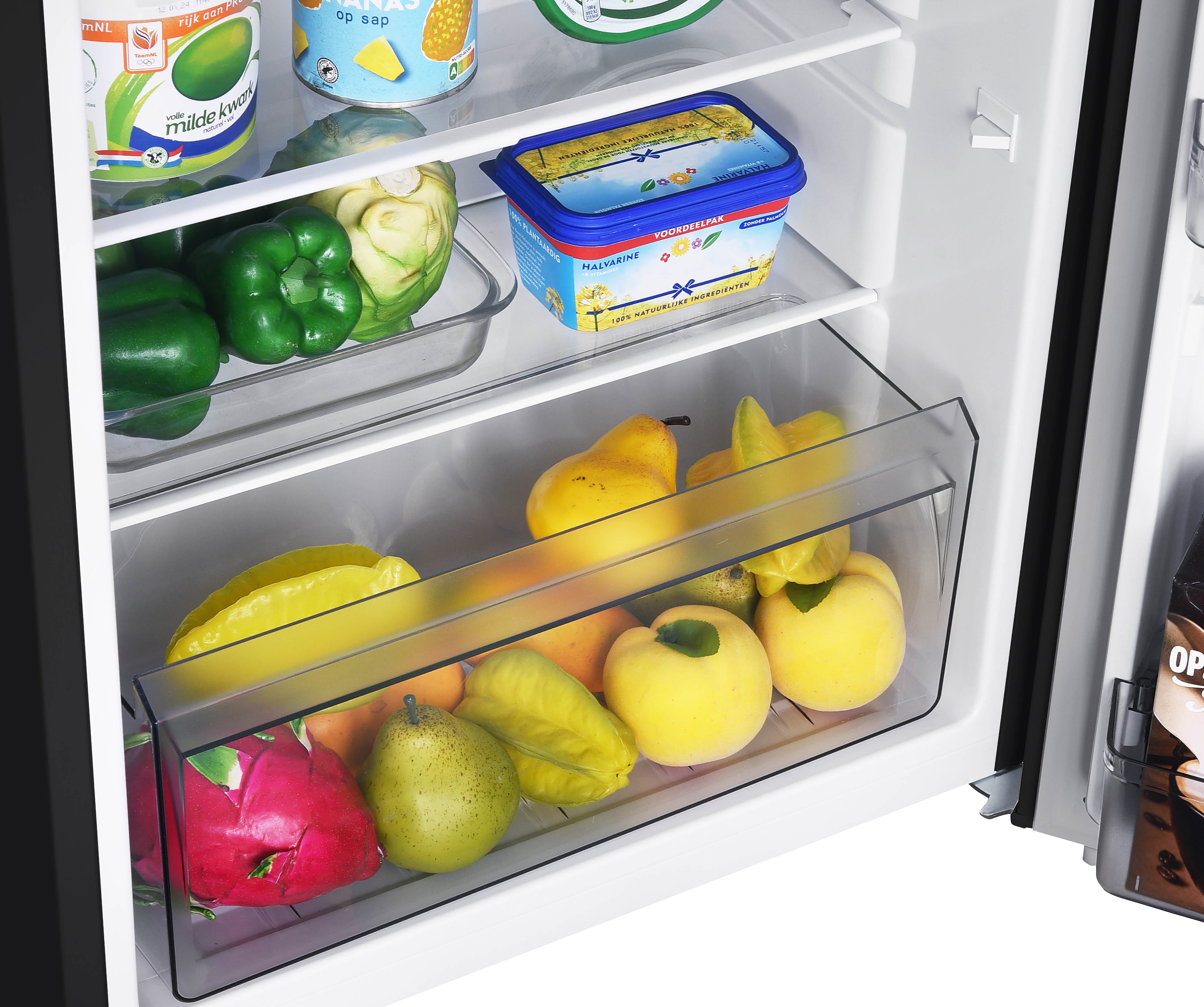 Interieur van de koelkast met planken vol voedsel: fruit, groenten en zuivelproducten.
