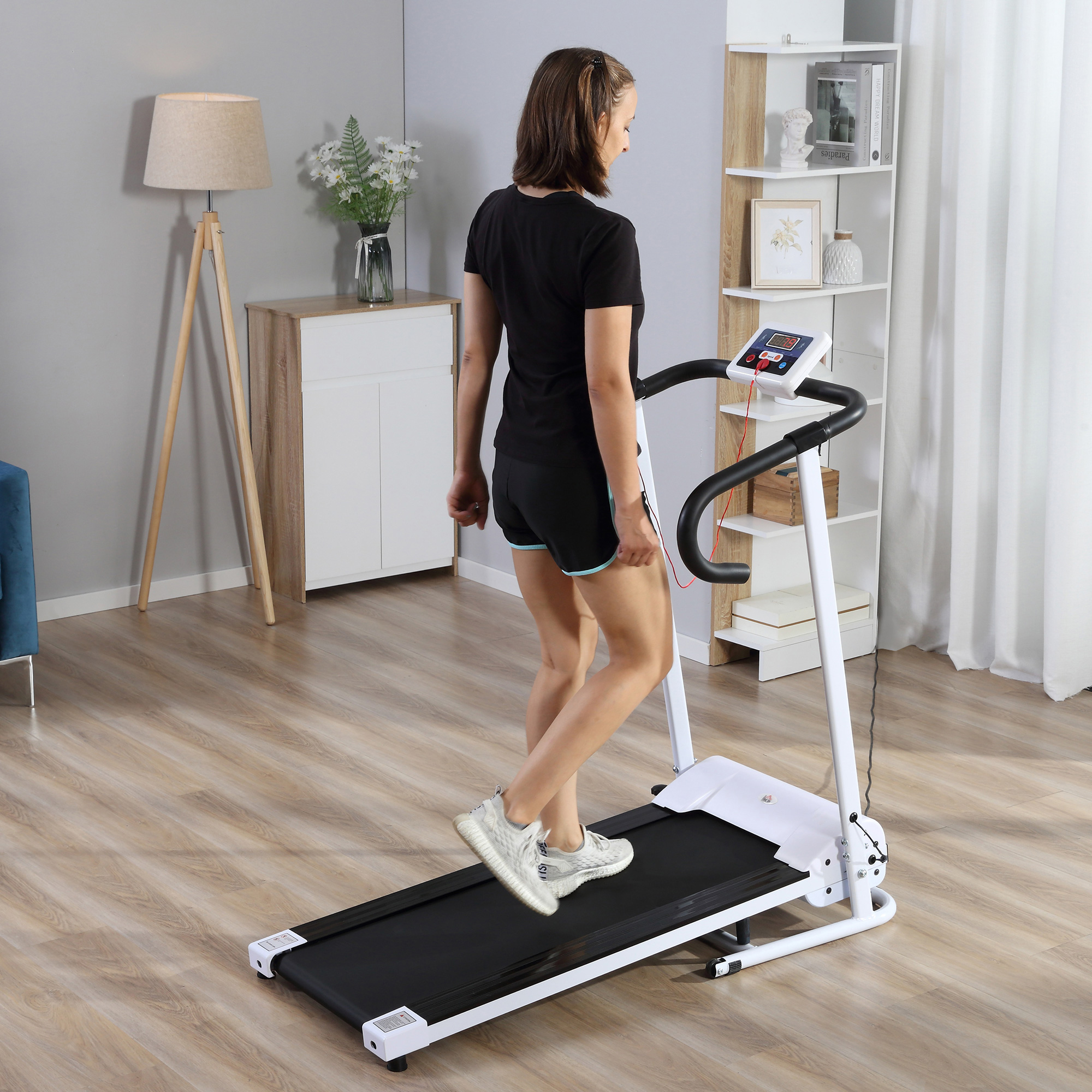 Donna su un tapis roulant. Abito nero, scarpe bianche, che corre a casa.