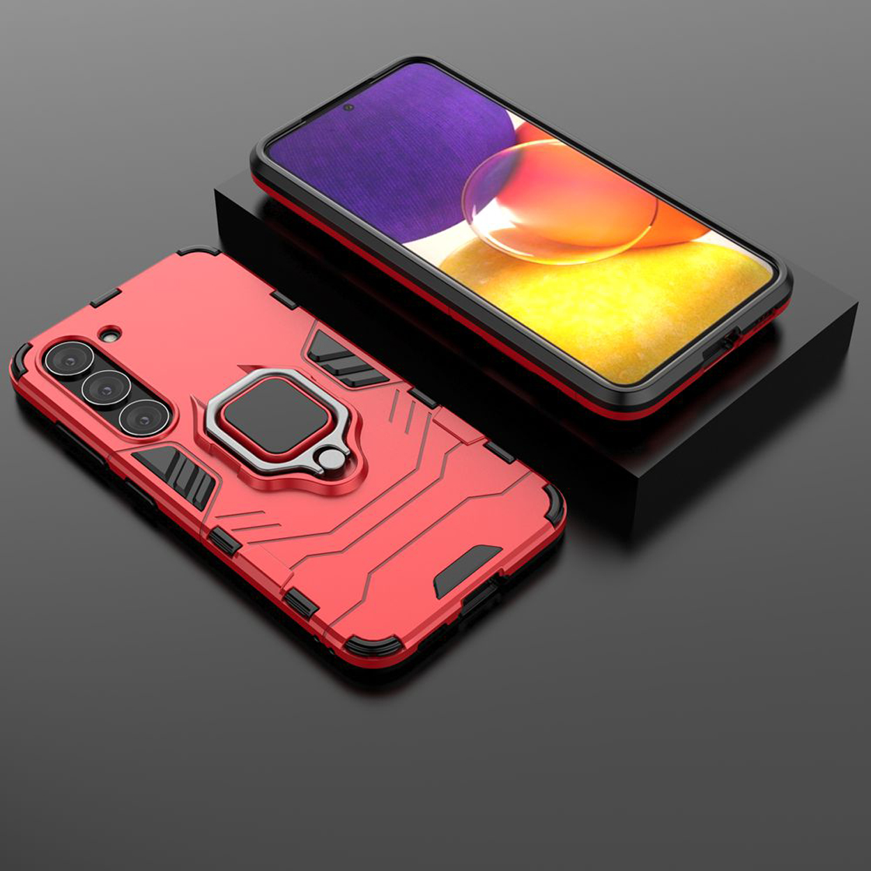 Rode telefoonhoes met een ringhouder. Een zwarte telefoon op een zwart oppervlak. Andere telefoon in zwarte hoes.