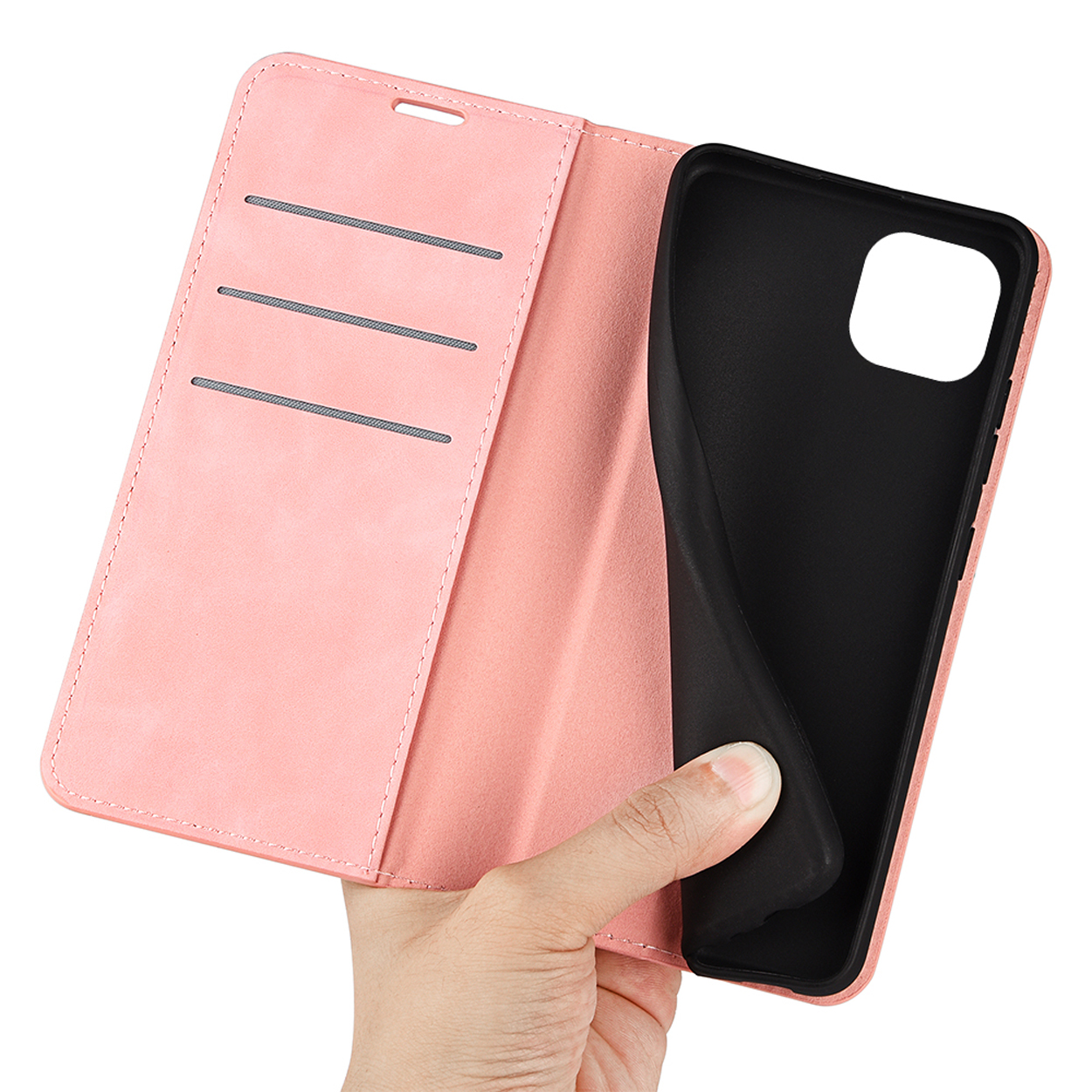 Hand hält eine rosa Handyhülle, offen. Das Telefon ist nicht in der Hülle. Schwarzer Innenraum.