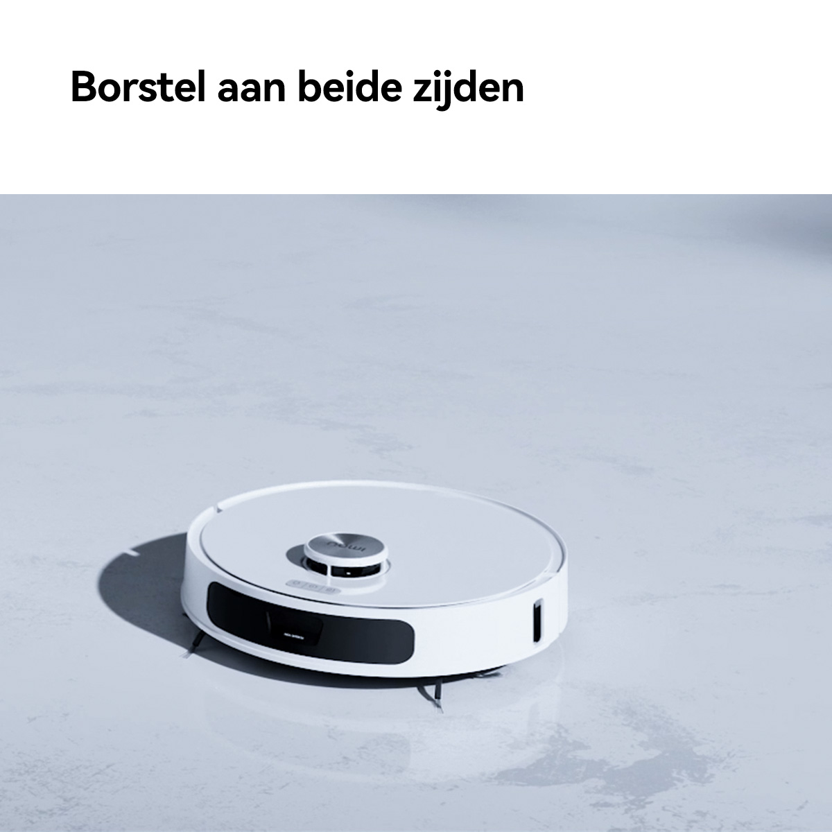 Aspirapolvere robotico bianco su un pavimento grigio chiaro, con la scritta "Spazzola su entrambi i lati".