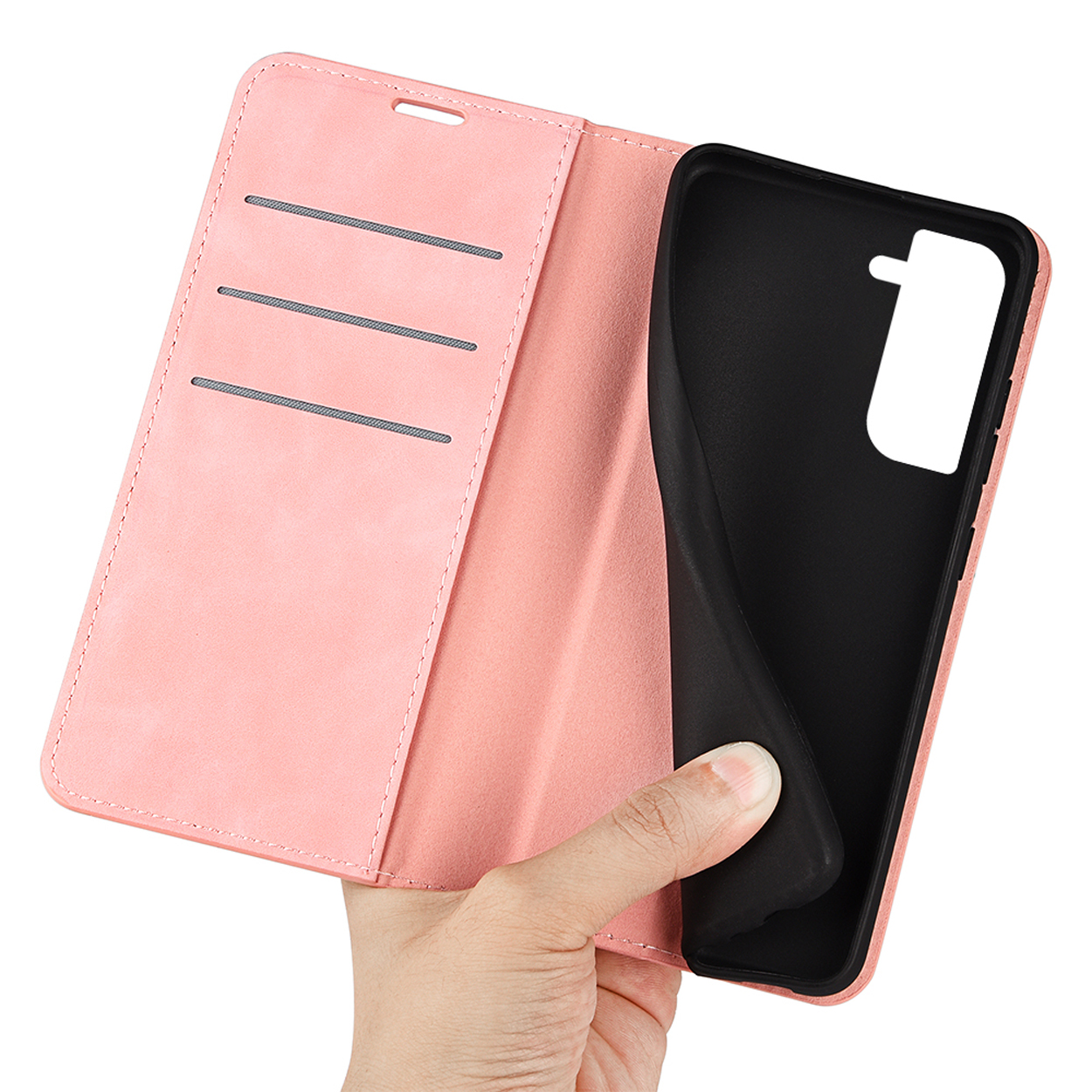 Une coque de téléphone rose, ouverte, avec une main qui la tient. Elle a une coque de téléphone noire à l'intérieur.