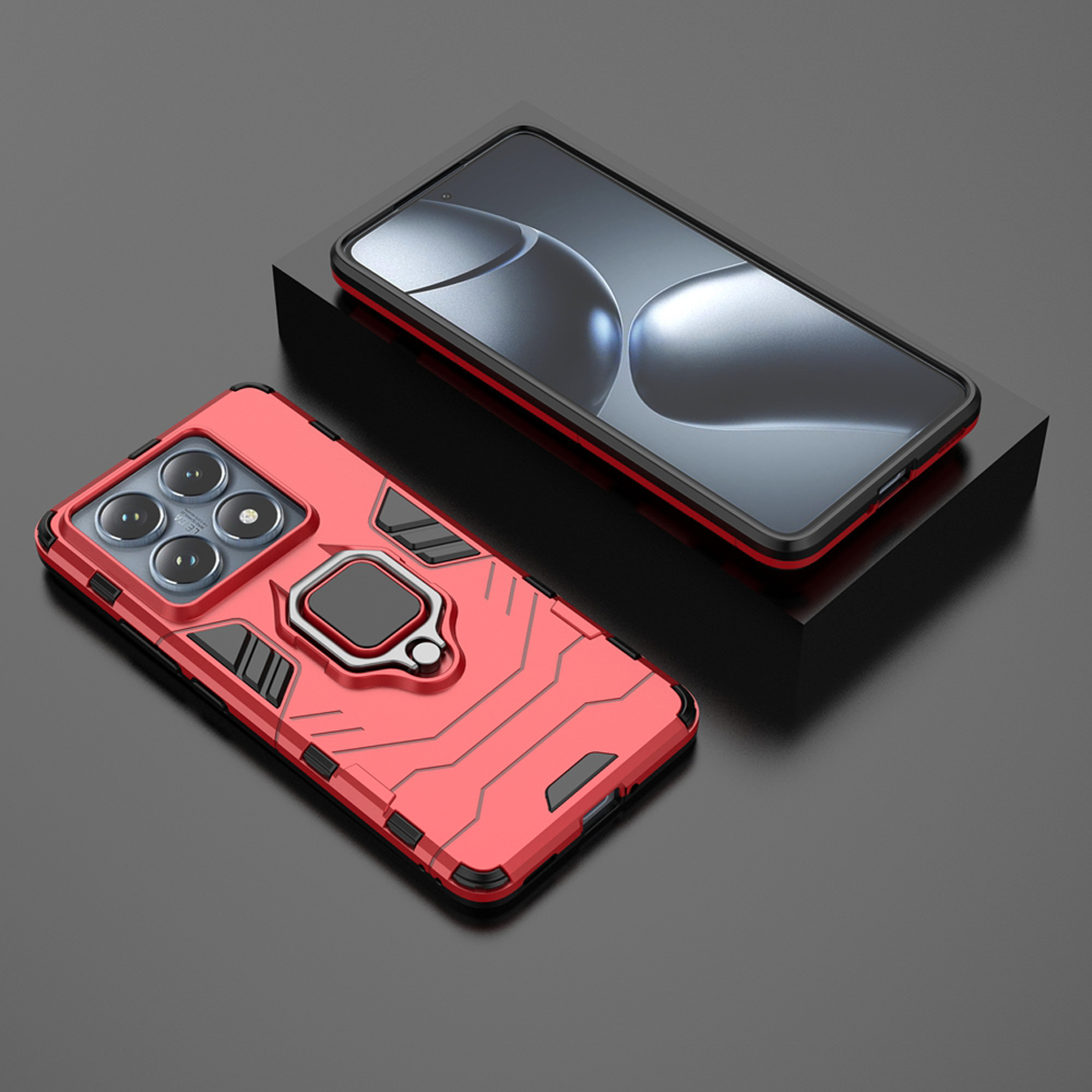 Een rode telefoonhoes met een ringstandaard op een zwart oppervlak, met een telefoon bovenop een zwarte doos.