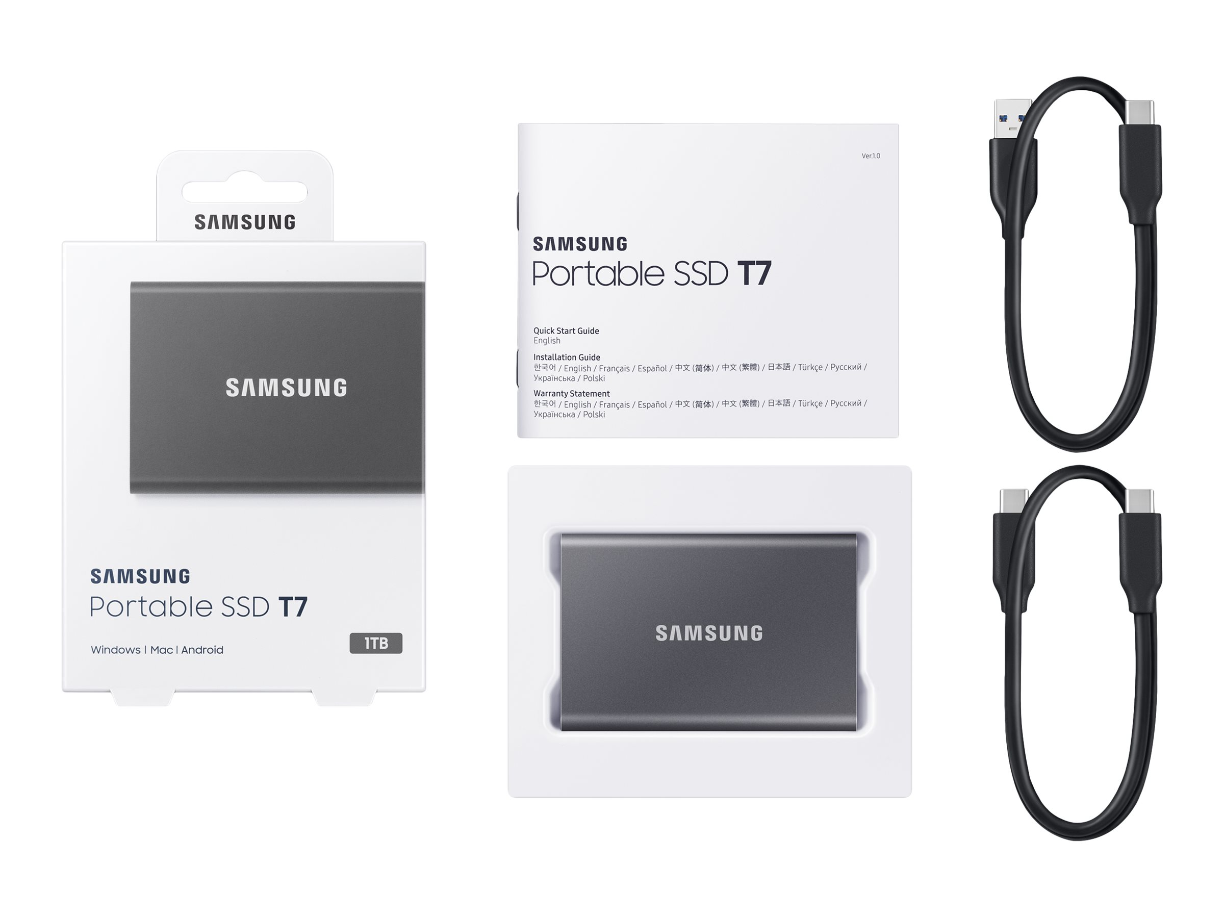 Eine verpackte SSD-Festplatte mit USB-Kabel, eine tragbare SSD und ein USB-C-Kabel. Alle Artikel sind grau.