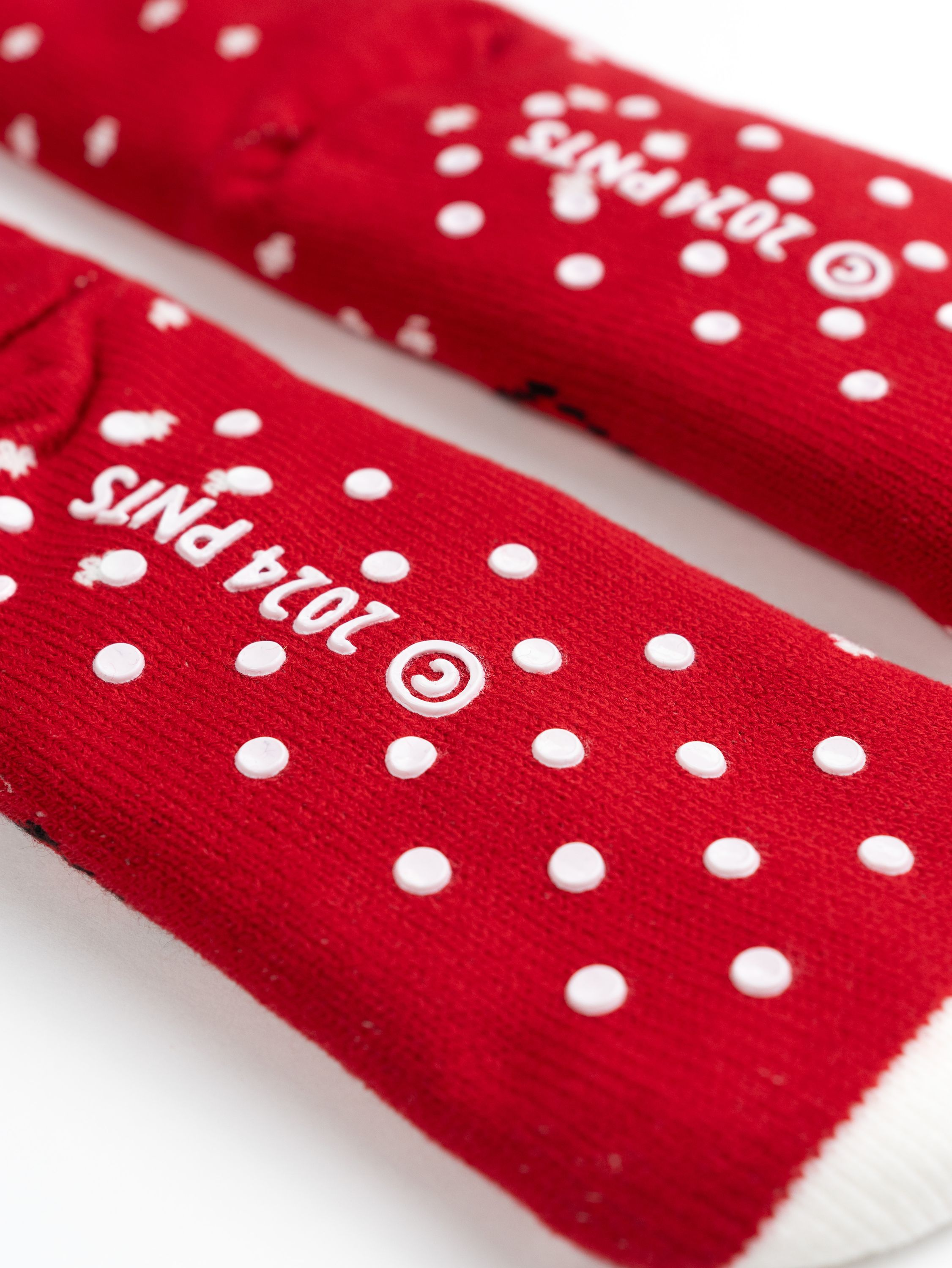 Rote Socken mit weißen Punkten und dem Text "2024 PNTS" aufgedruckt.