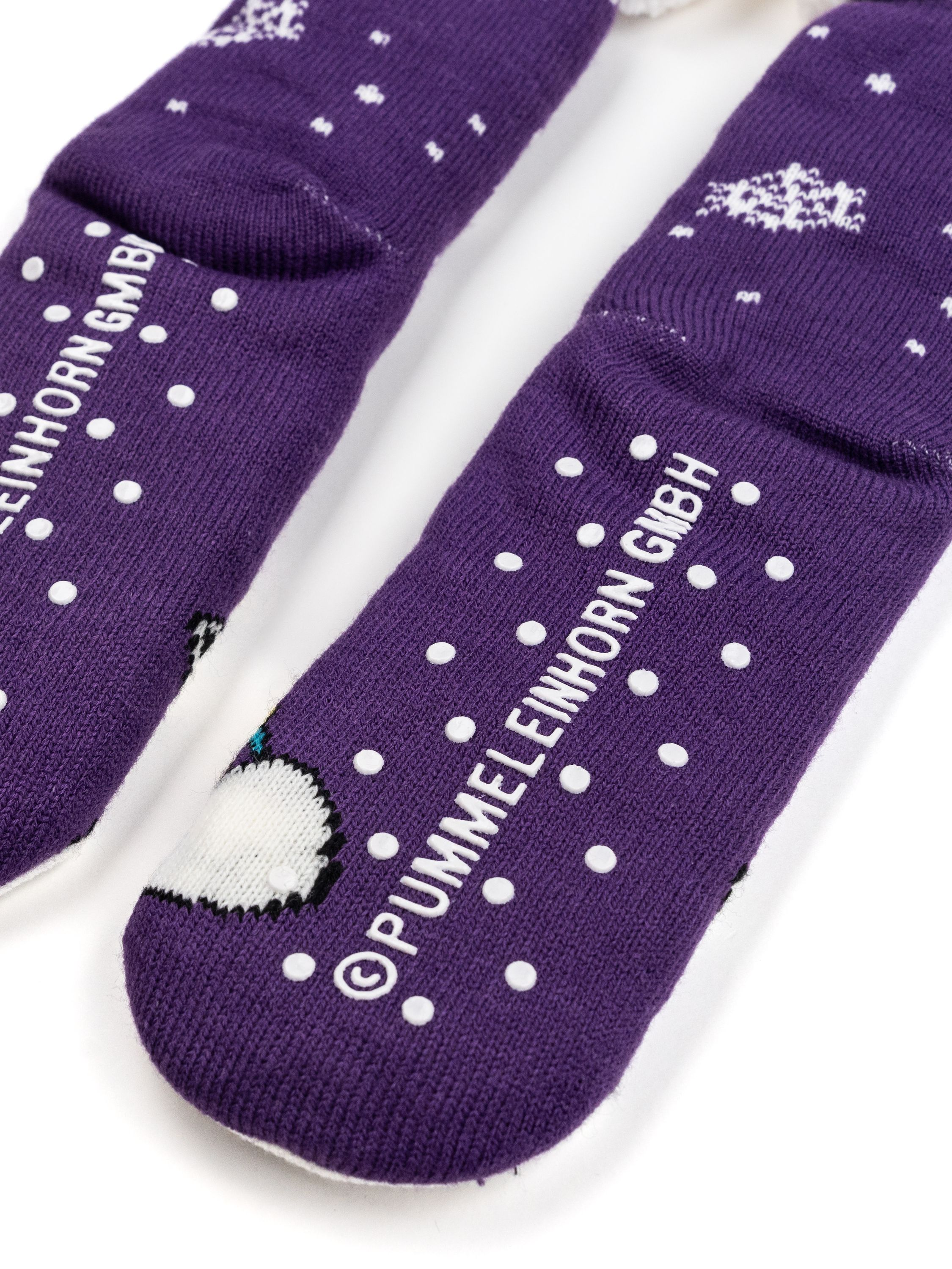 Lila Socken mit weißen Punkten. Weißer Boden mit Punkten und einer kleinen Illustration.