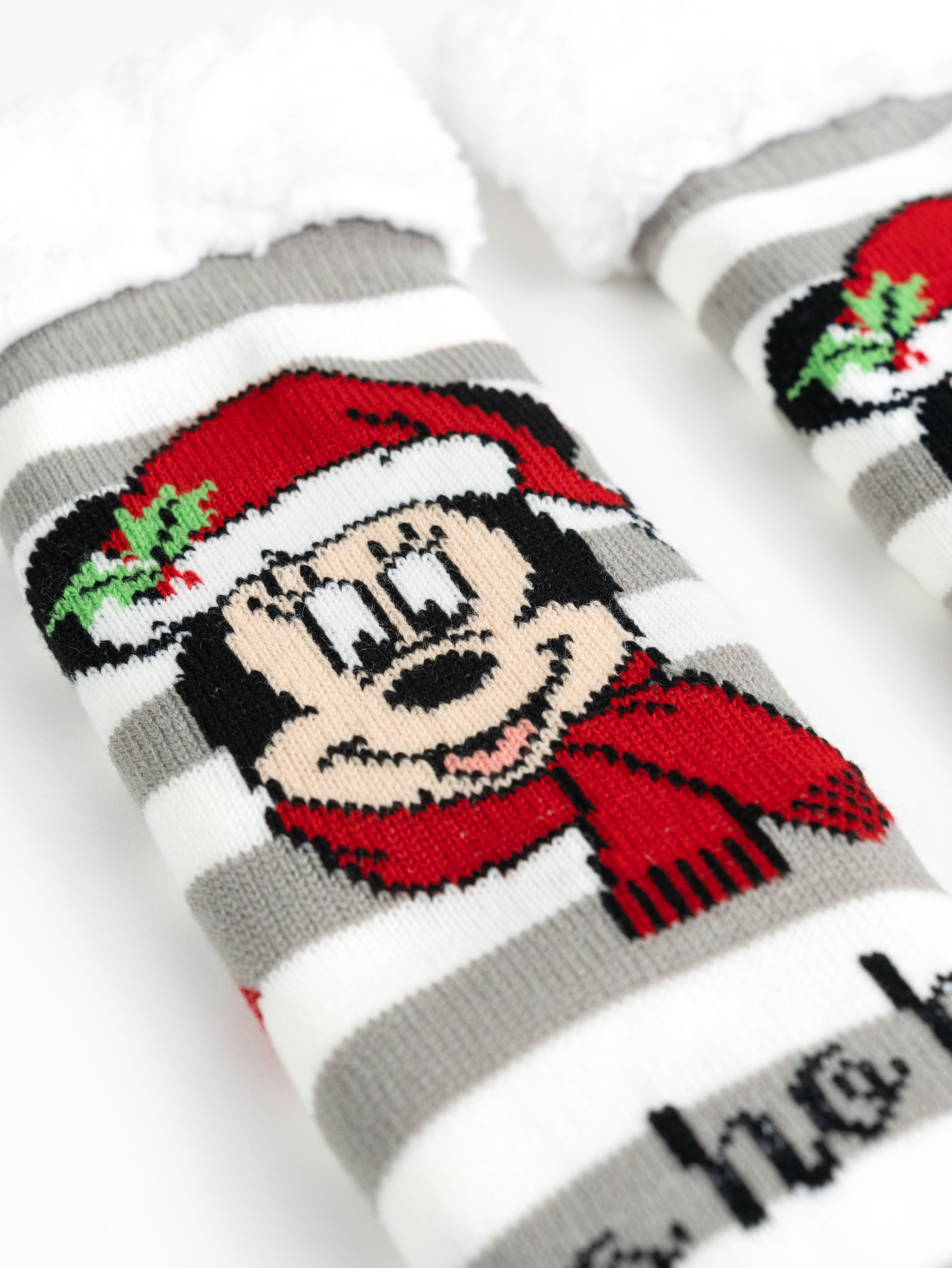 Nahaufnahme von gestreiften Socken mit Minnie Mouse-Gesicht und flauschigem weißen Rand.