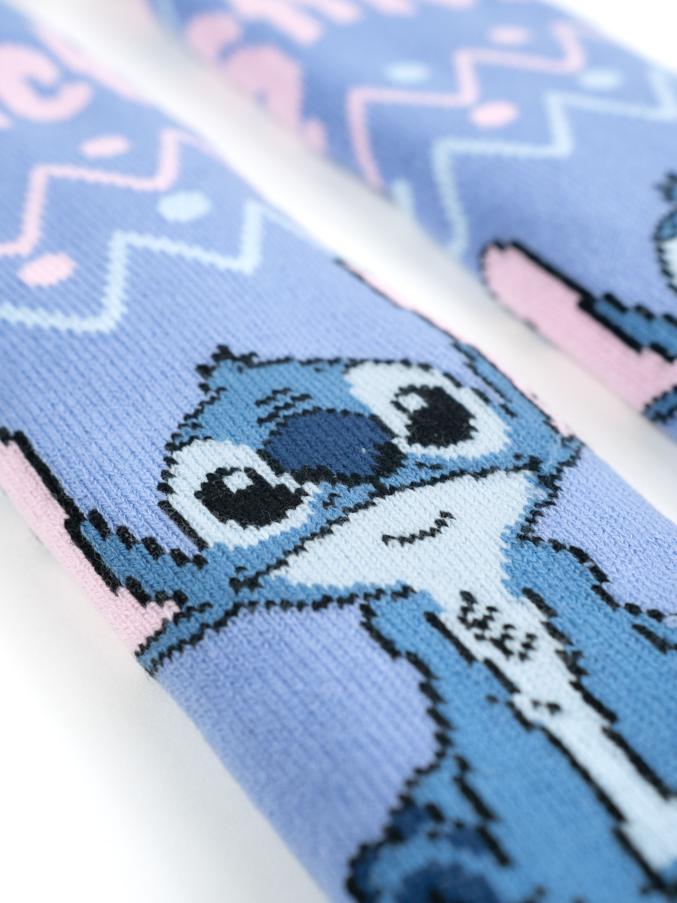 Paar blaue Stitch-Socken mit Stitch-Gesicht und gemustertem Design.