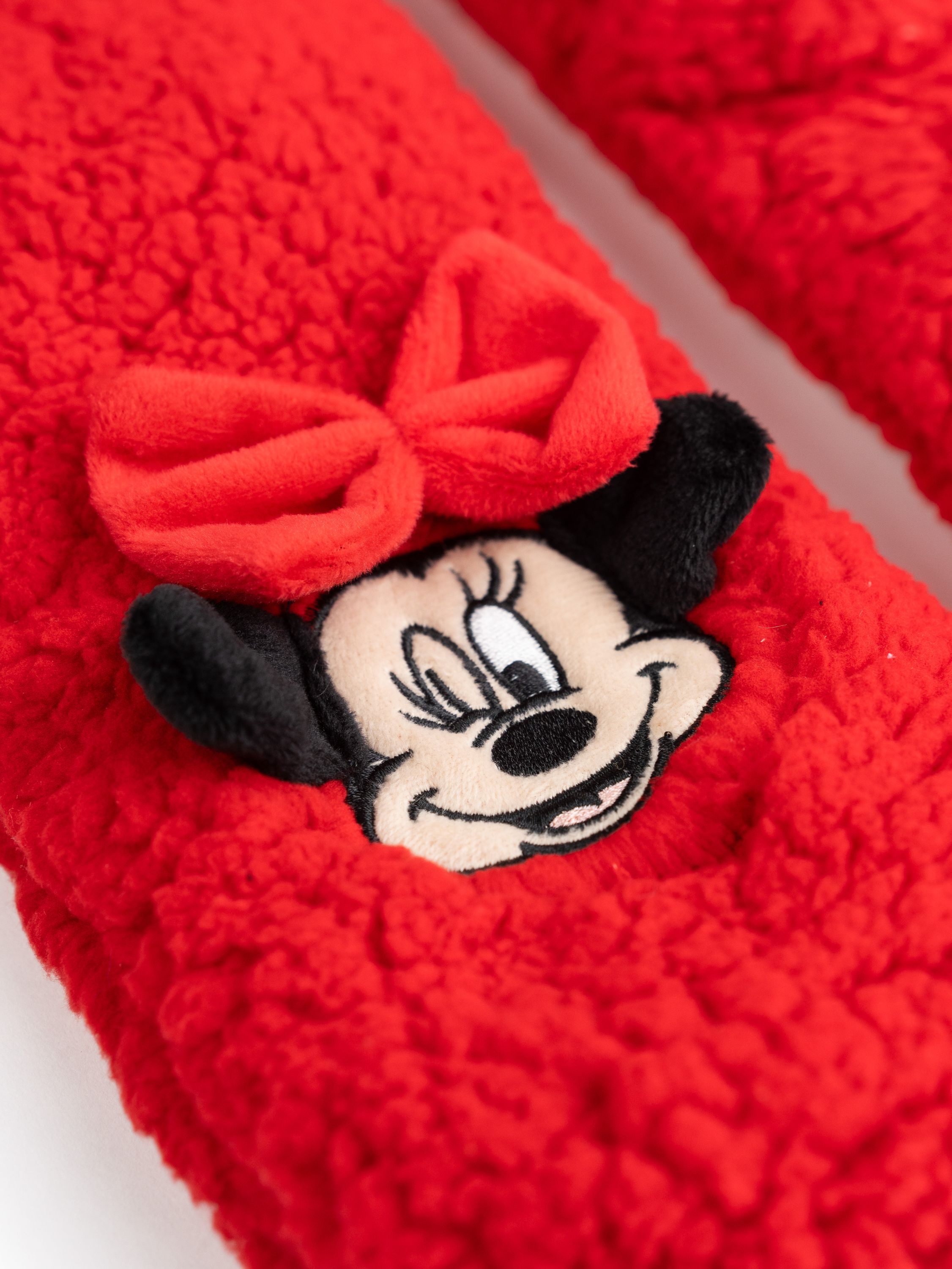 Rote, pelzige Minnie Mouse Socken. Minnie's Gesicht ist auf den Socken, mit einer roten Schleife oben drauf.