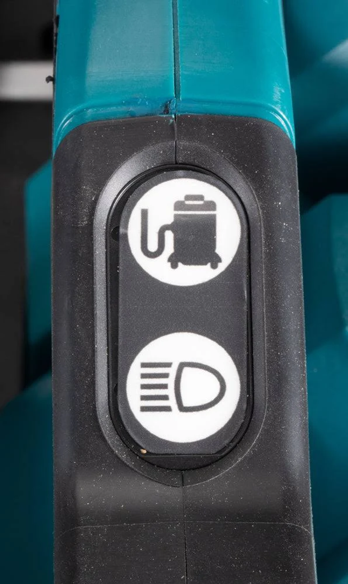 Primer plano de un panel de control negro y azul verdoso con iconos para una aspiradora y una luz.