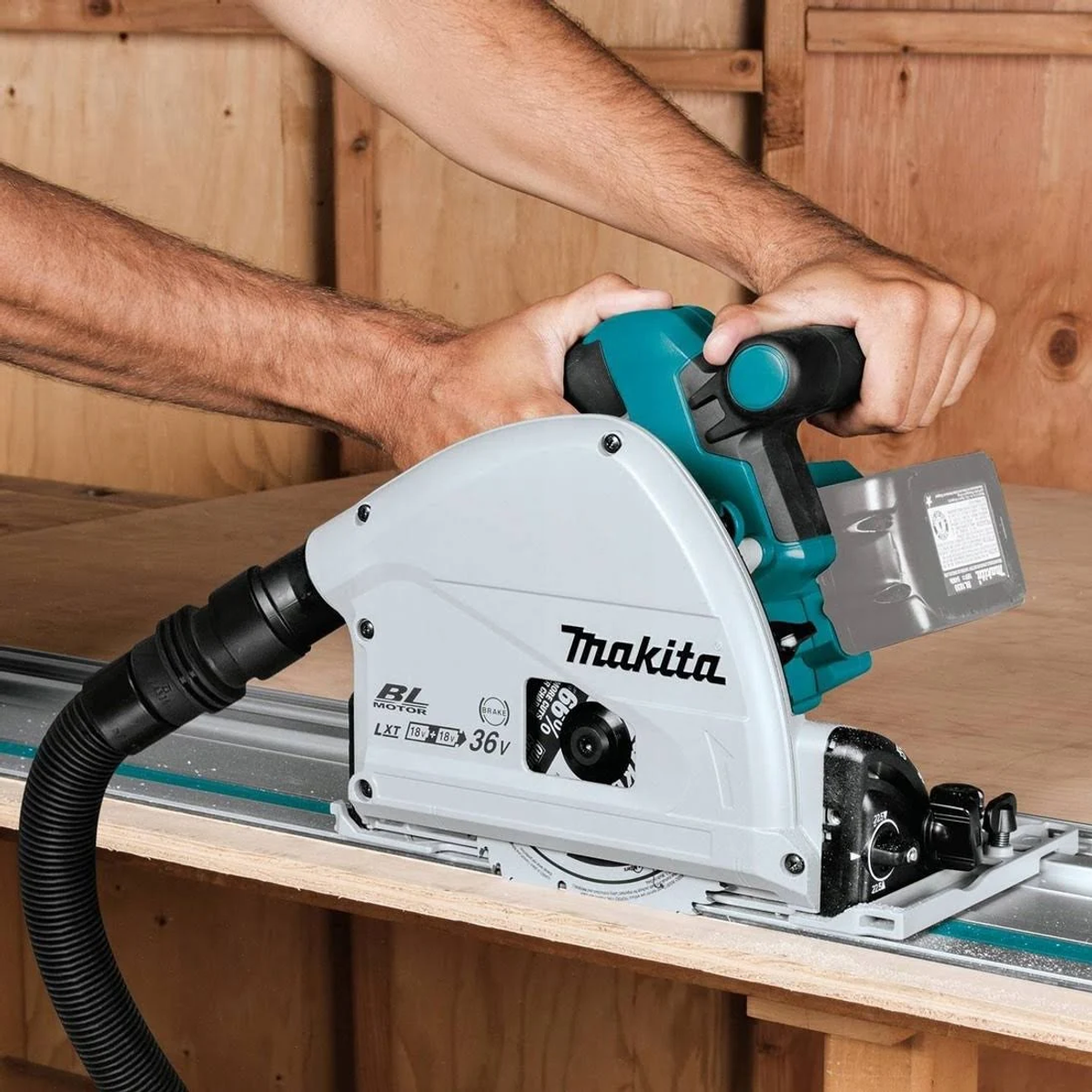 Una persona usa una sierra circular Makita turquesa y gris sobre una superficie de madera.