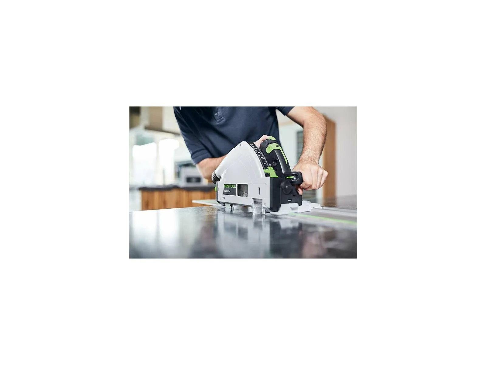 Person schneidet mit einer Festool Kreissäge eine dunkle Arbeitsplatte in der Küche.