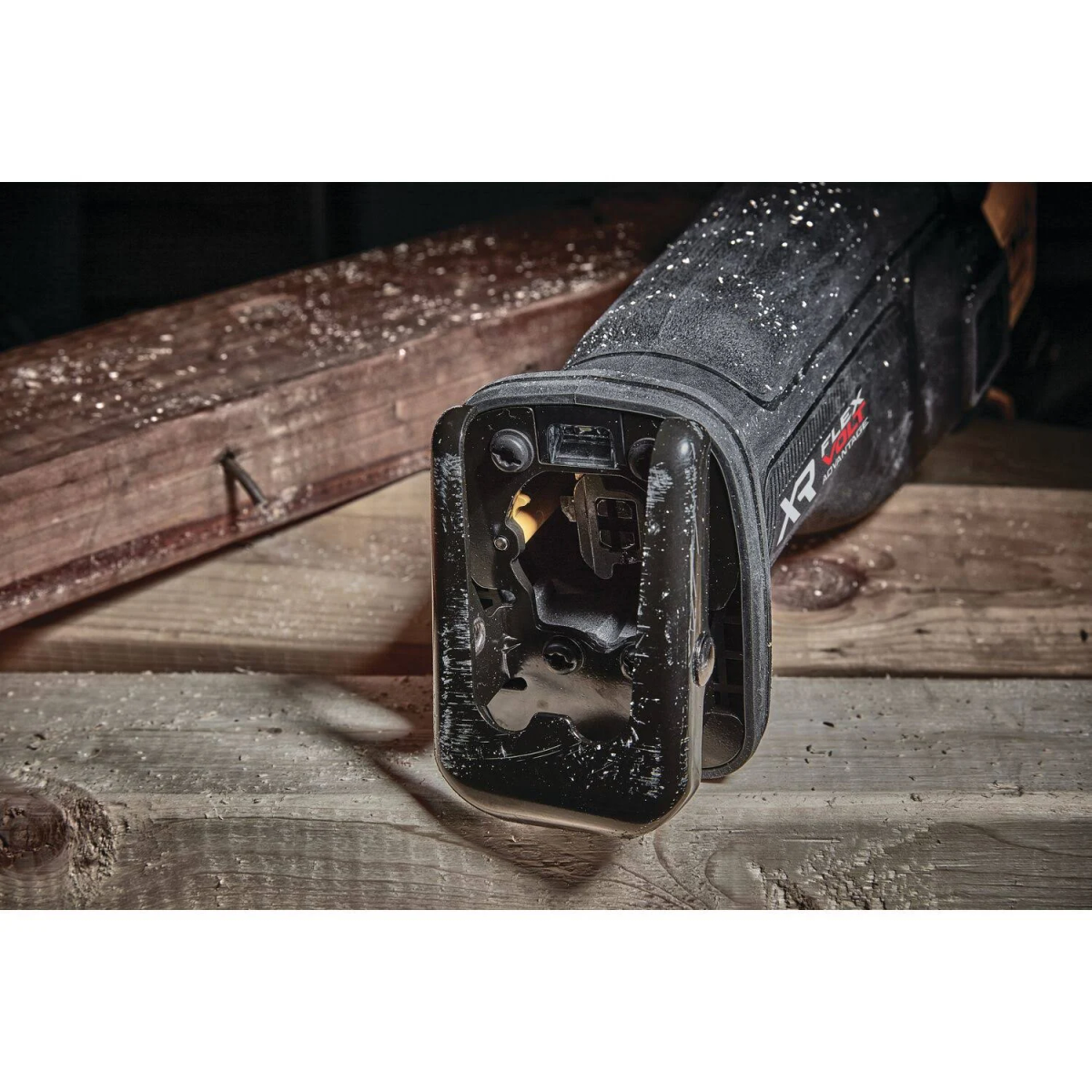 Zbliżenie piły posuwisto-zwrotnej z drewnianą deską w tle.