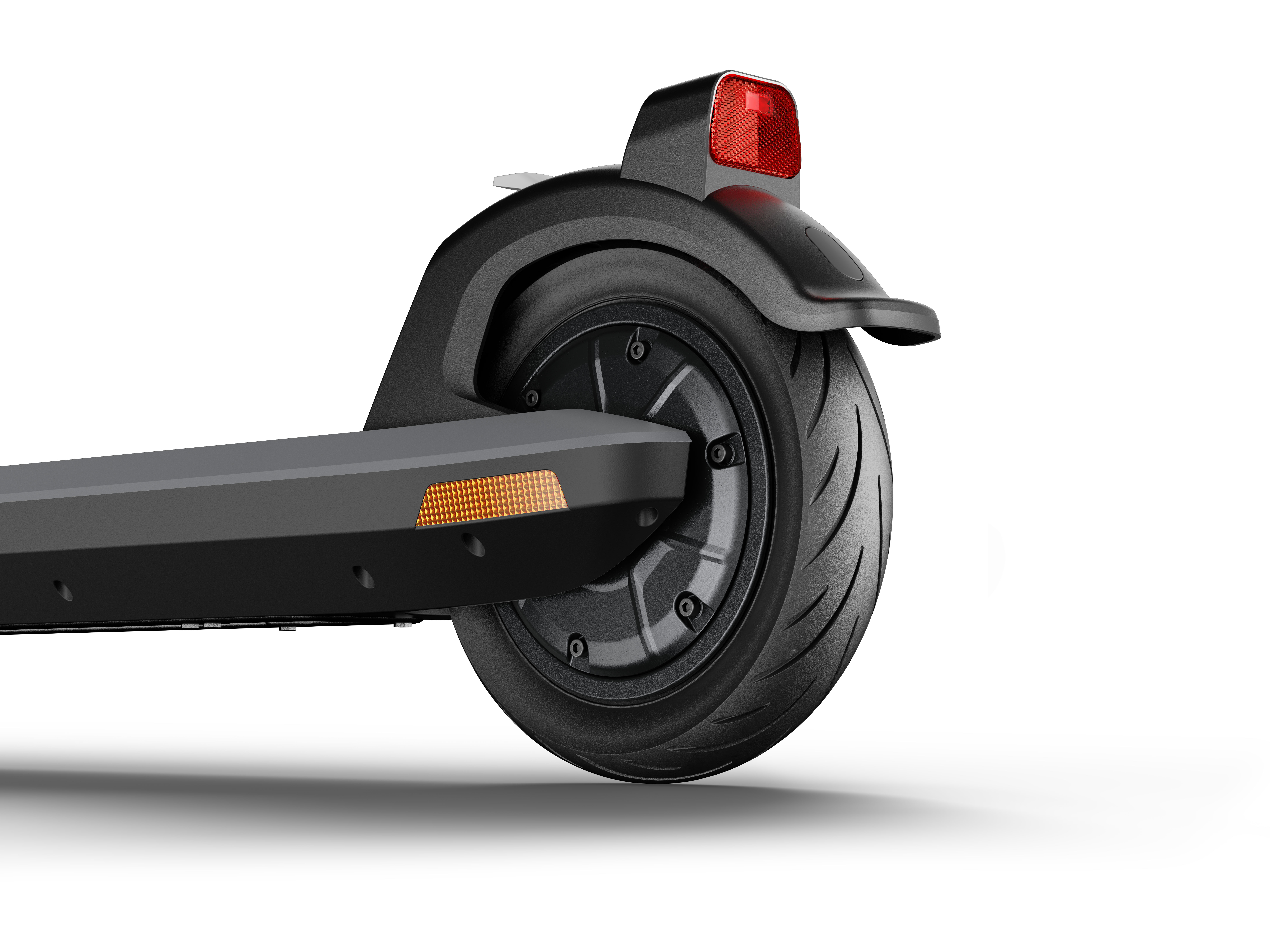 Primer plano de la rueda trasera de un patinete eléctrico negro. Un reflector rojo encima.