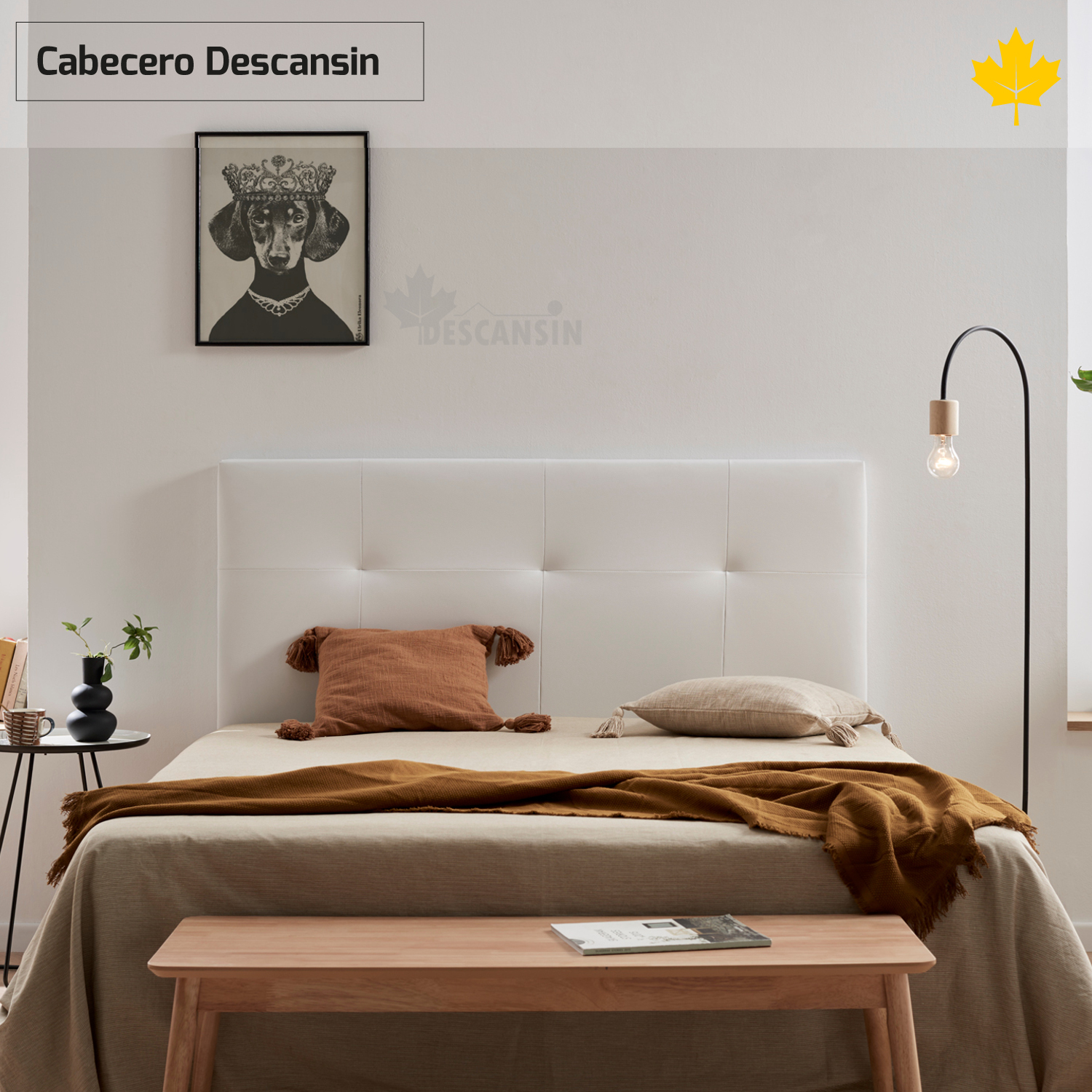 Dormitorio con cama blanca y banco de madera. Una lámpara negra y una obra de arte enmarcada. Manta marrón.