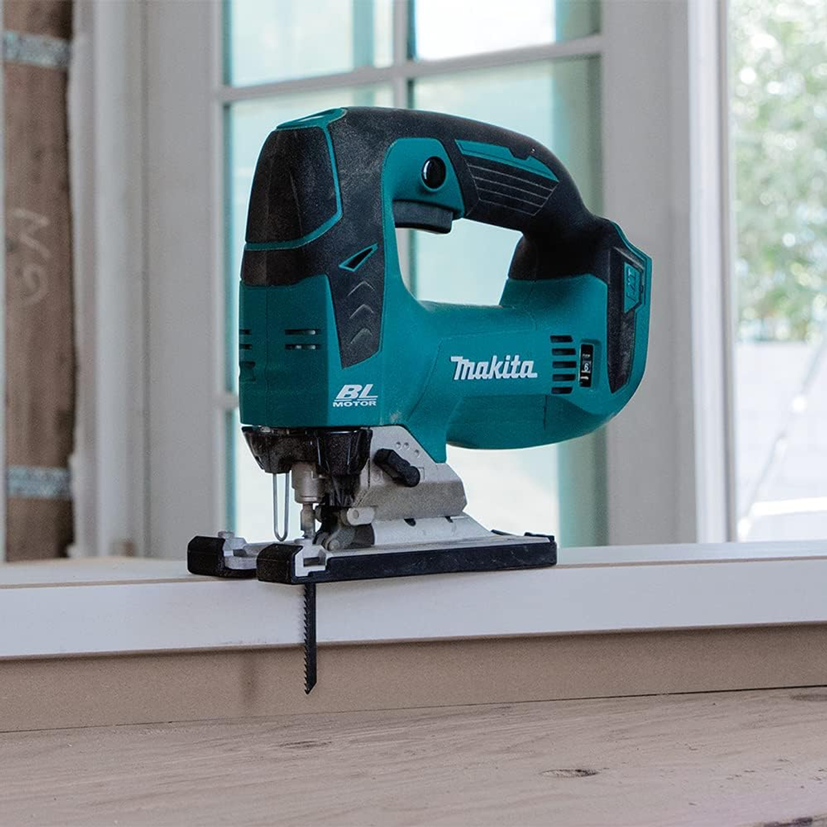 Seghetto alternativo Makita, verde acqua e nero, su un davanzale bianco.