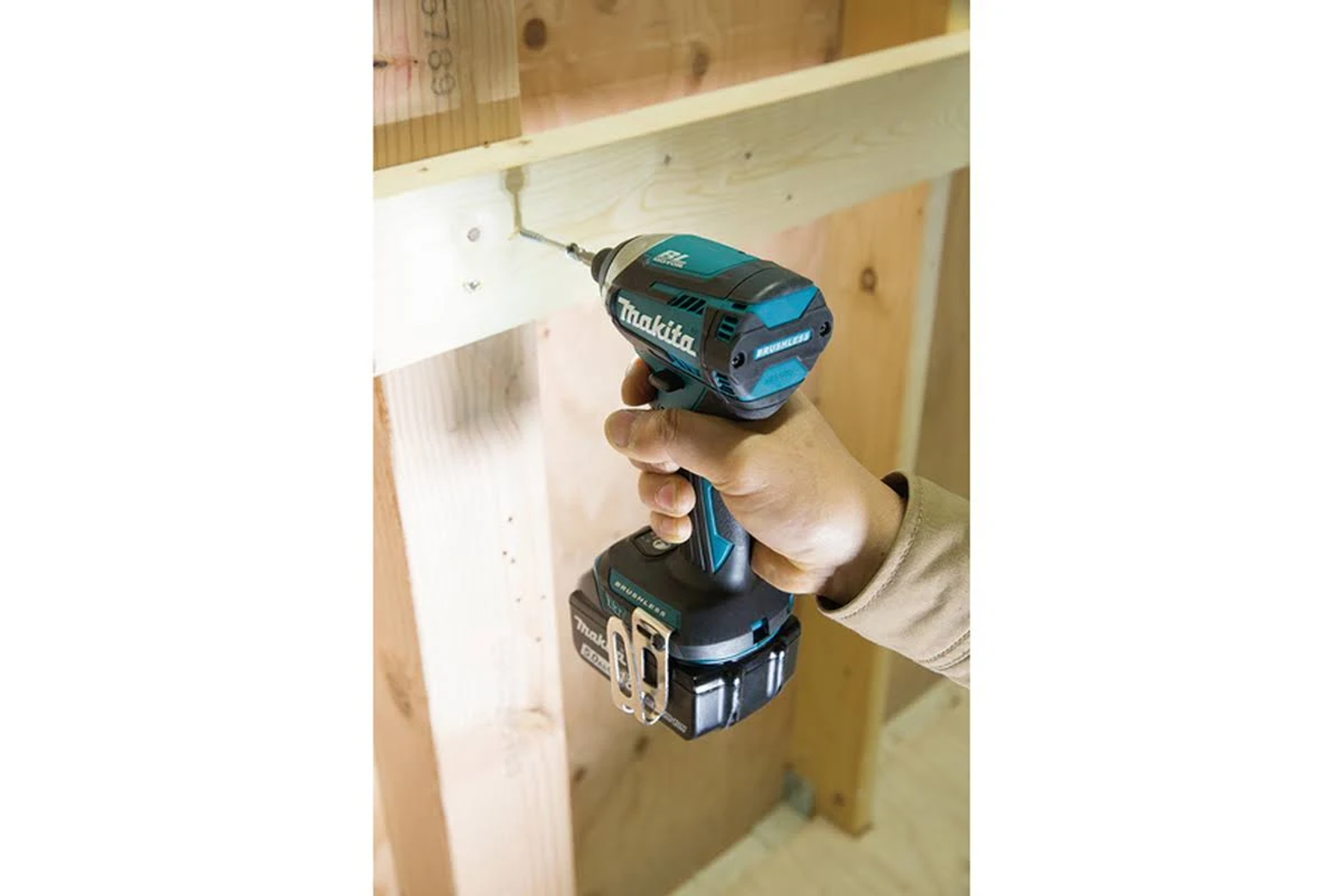 Una persona tiene un trapano Makita, lo usa sul legno. Il trapano è in azione.