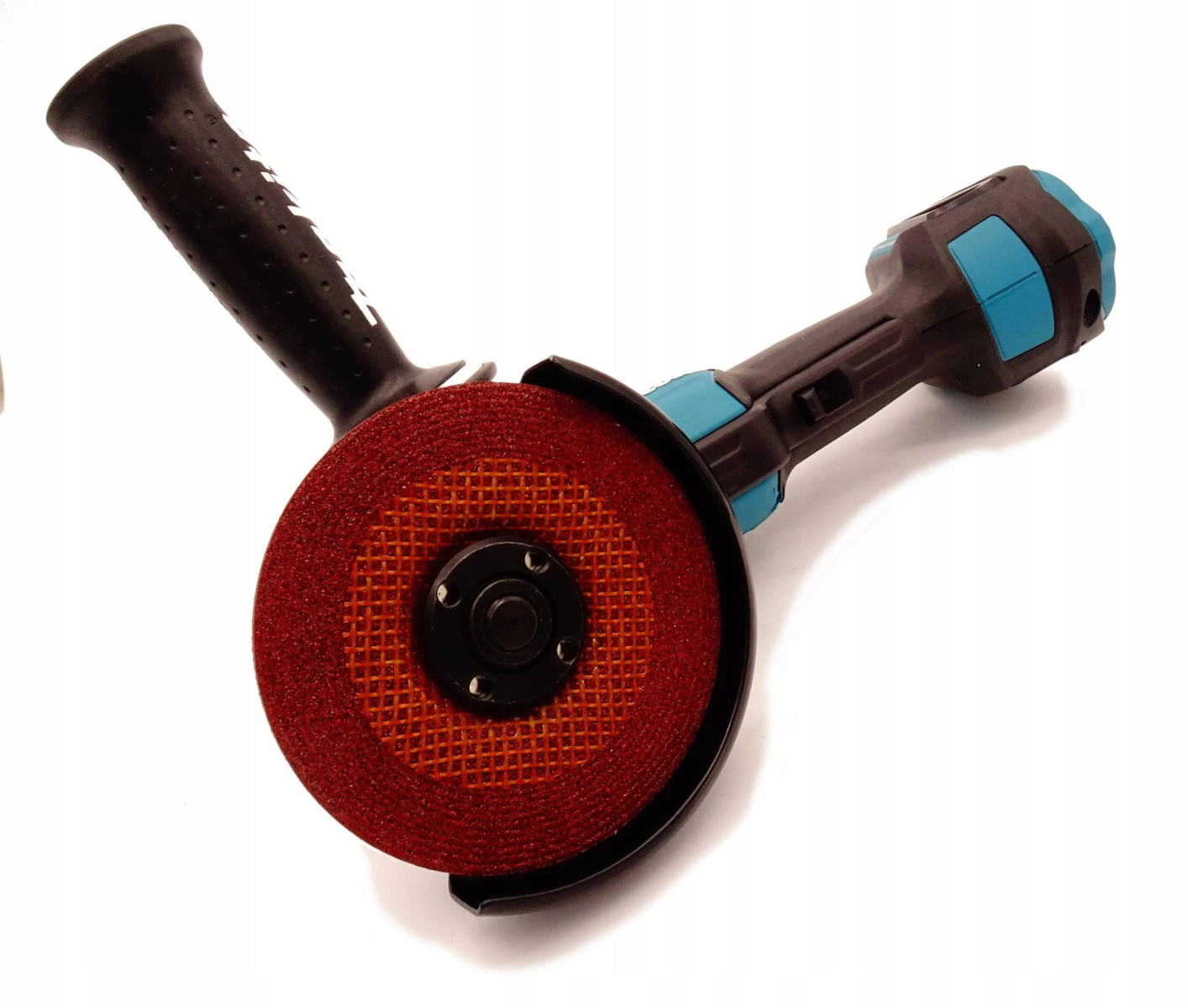 Una amoladora angular con una muela roja, mango negro y azul.