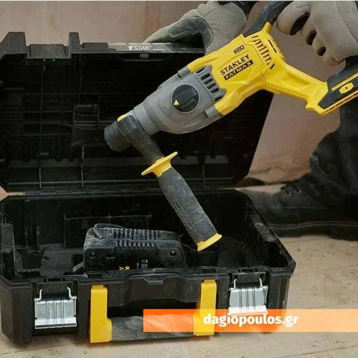 Gelb-graue Stanley Fatmax Hammerbohrmaschine in einem schwarzen Koffer. Eine Batterie ist sichtbar.