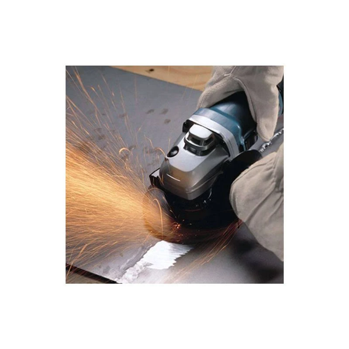 Persona usando una amoladora de metal. Las chispas vuelan. La amoladora es azul y plateada.