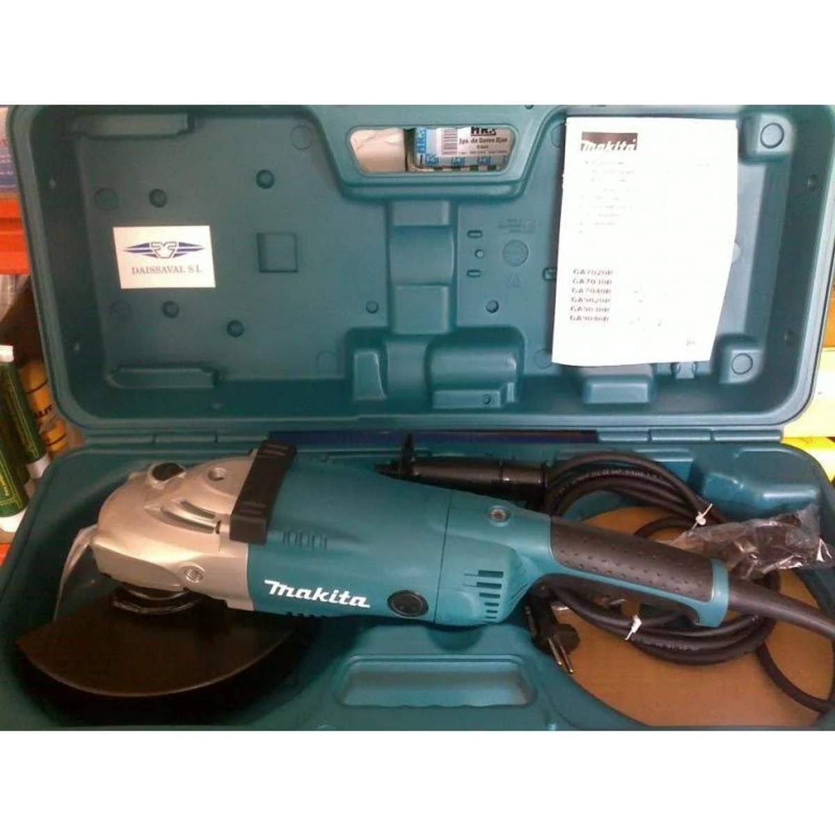 Amoladora Makita en una funda turquesa y negra. La herramienta es turquesa y plateada.