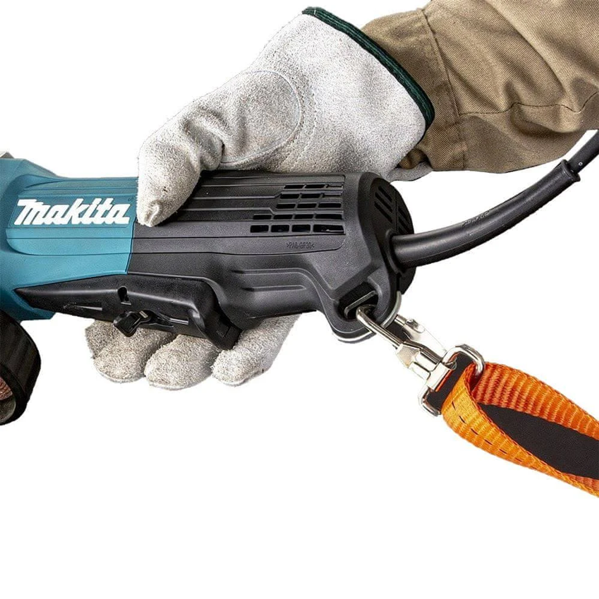 Una persona sosteniendo una herramienta Makita con una correa de seguridad, usando guantes de trabajo.