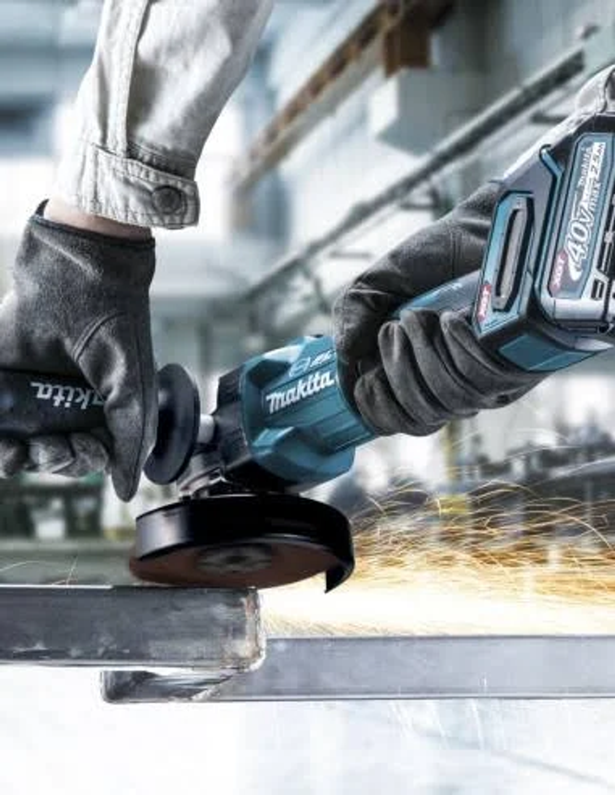 Persona usando una amoladora angular azul Makita, saltan chispas. Se está amolando una viga de acero.