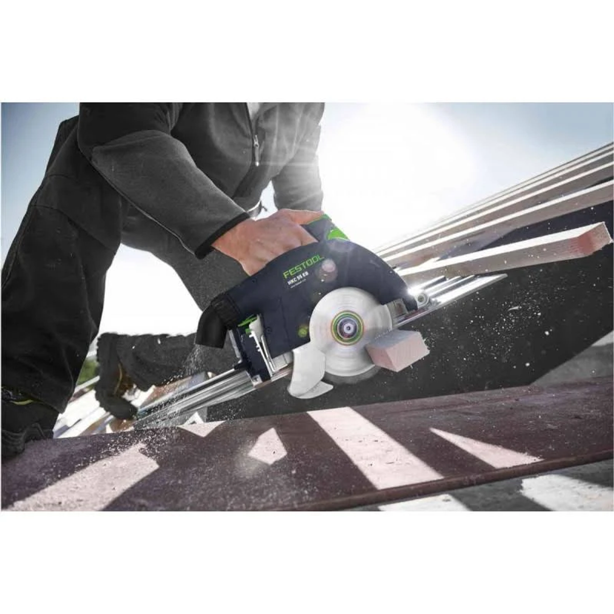 Osoba używająca piły tarczowej Festool do cięcia drewna na dachu.