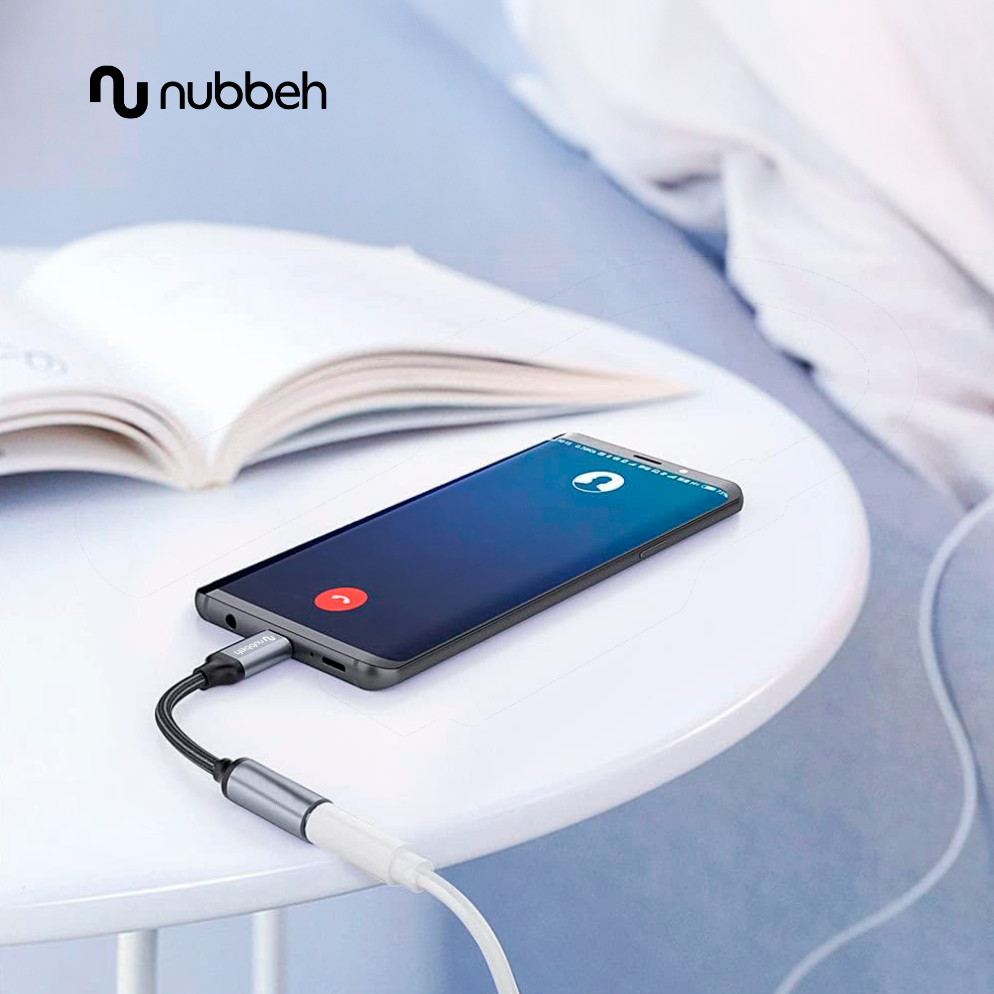 Un smartphone con pantalla de llamada conectado a un adaptador USB-C sobre una mesa.