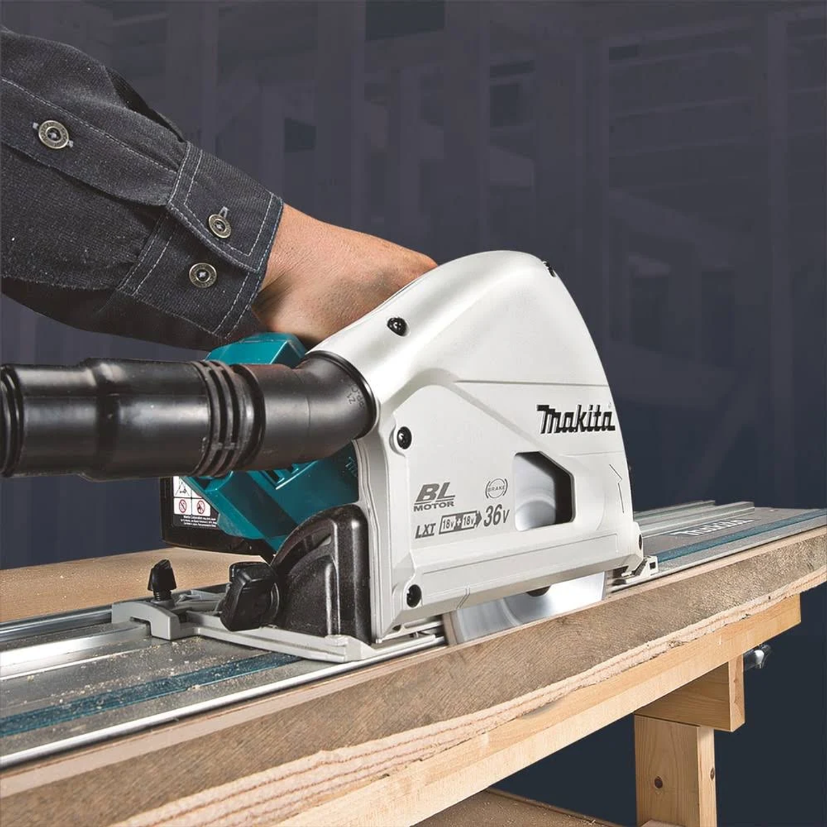 Hombre cortando madera con sierra circular Makita en mesa de madera. La sierra es blanca y verde azulado.
