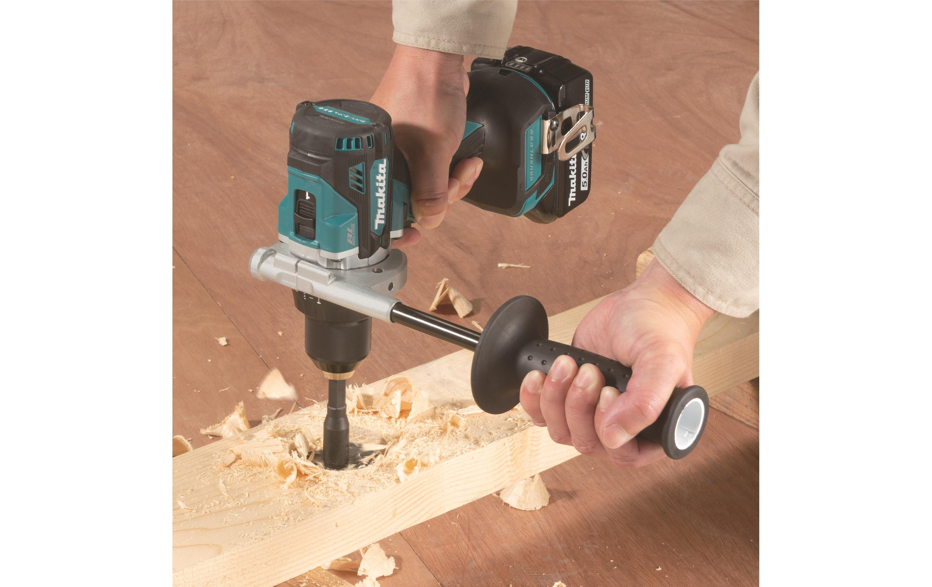 Osoba wierci w drewnianej desce za pomocą wiertarki elektrycznej Makita.